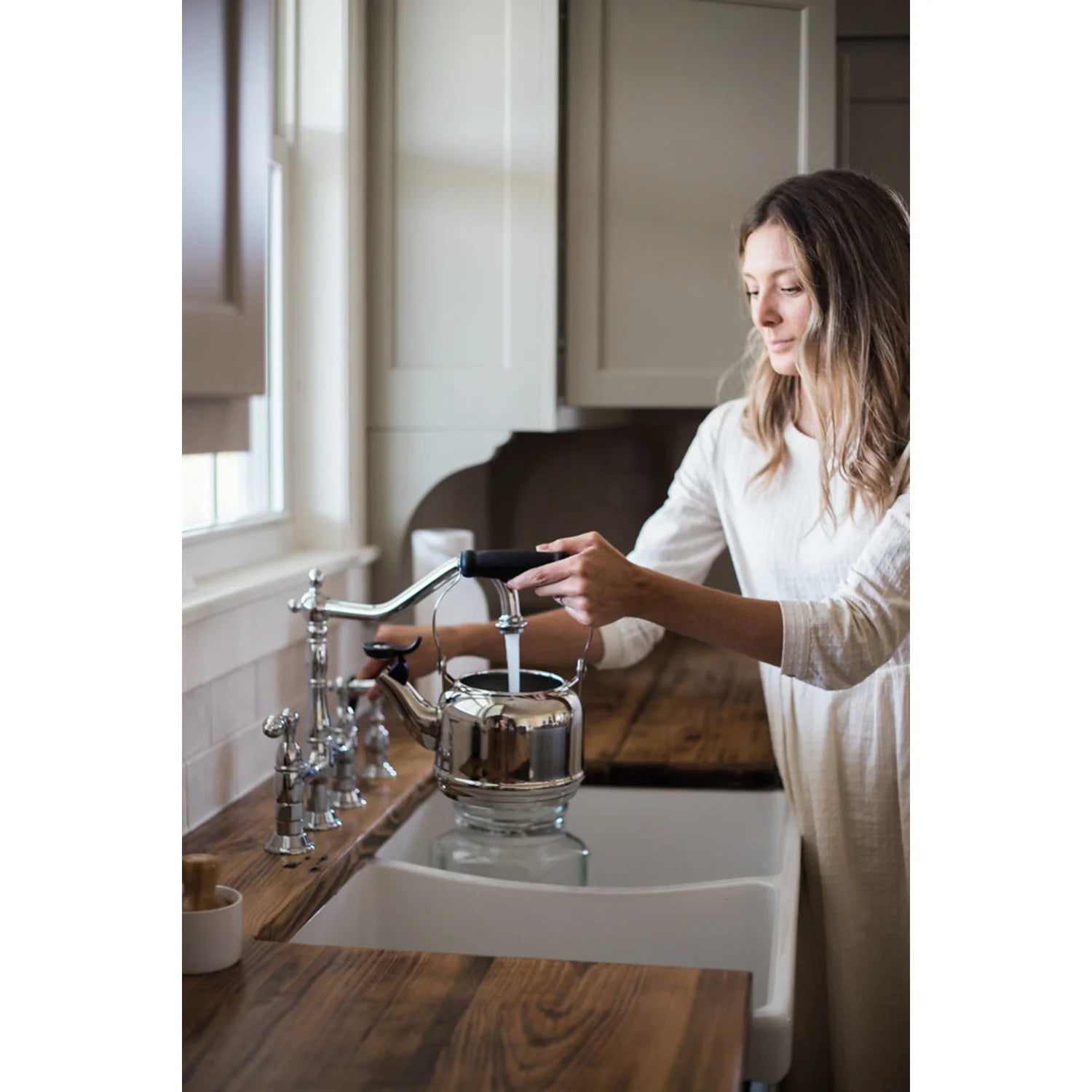 Polished chrome bridge kitchen faucet with side sprayer and deck-mounted handles