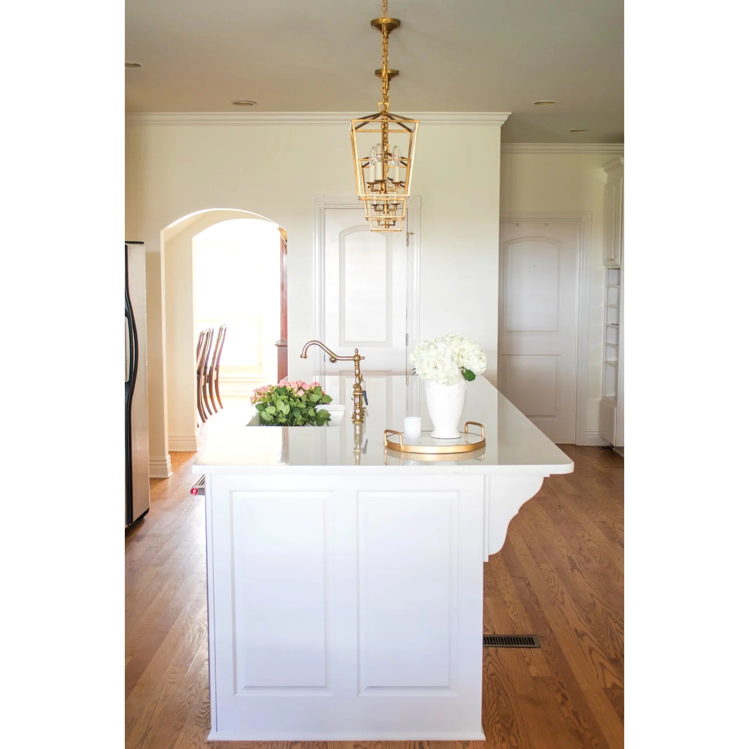 Polished brass bridge kitchen faucet with tall arched spout and side sprayer