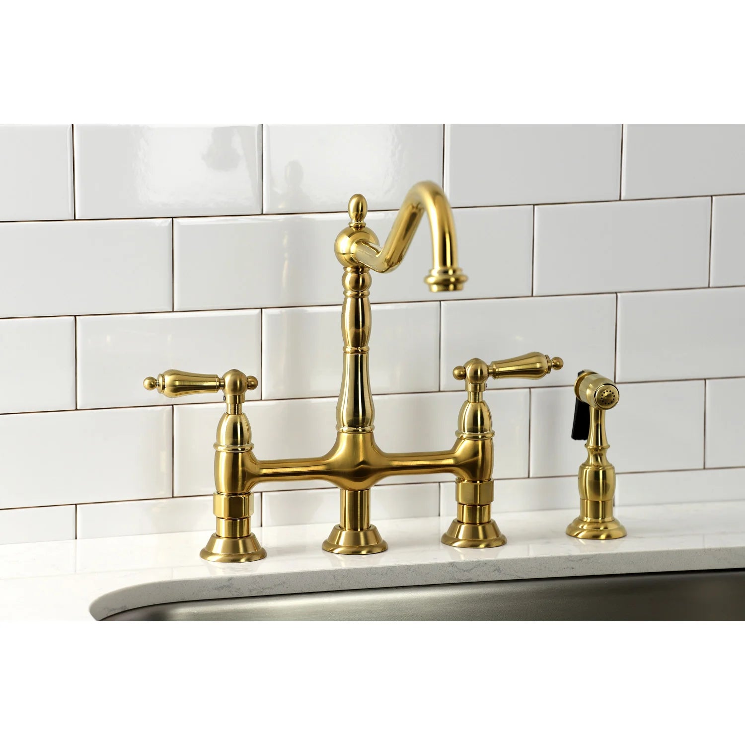 Brushed brass bridge faucet with deck-mounted handles and side sprayer