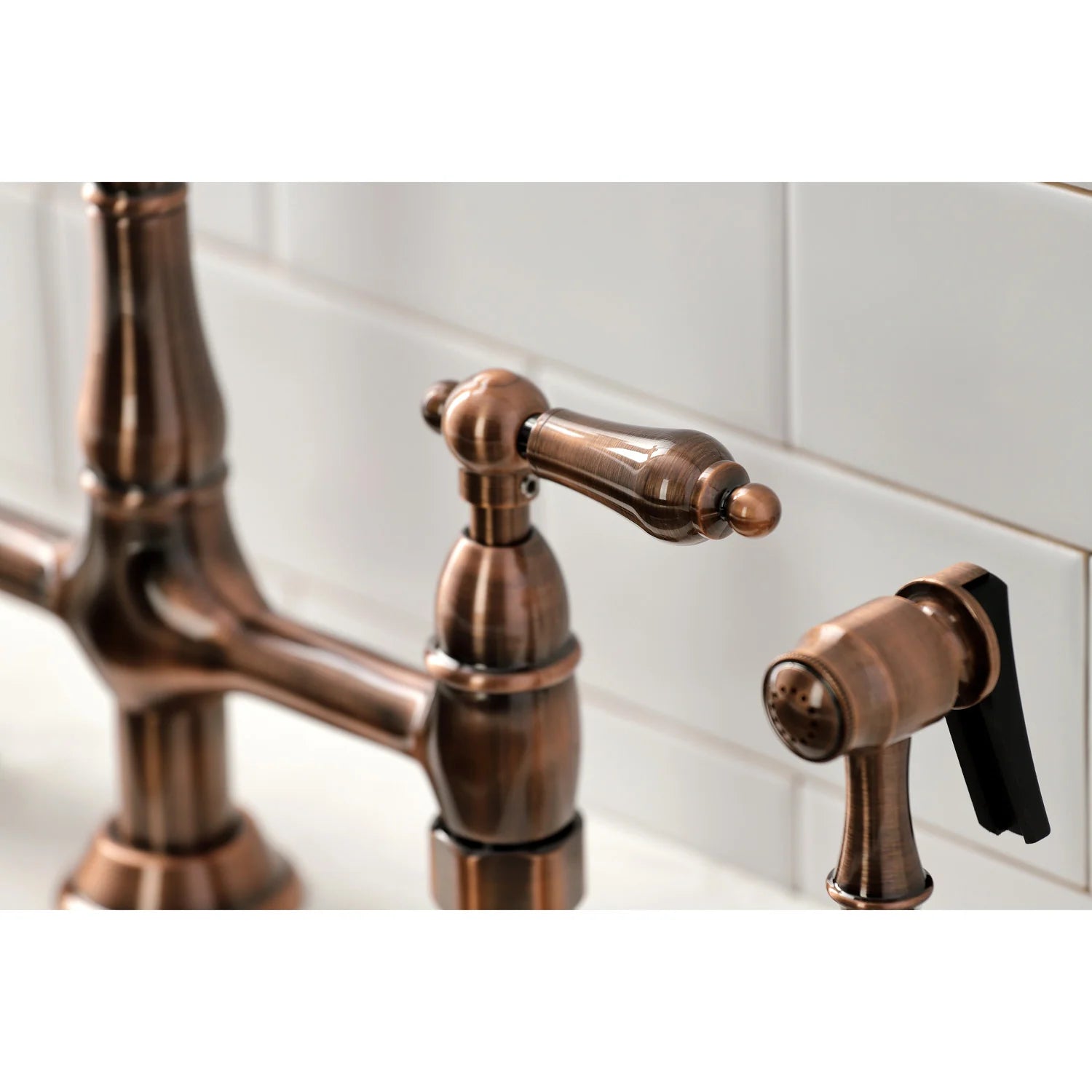 Antique copper side sprayer and bridge faucet spout with handles in close-up
