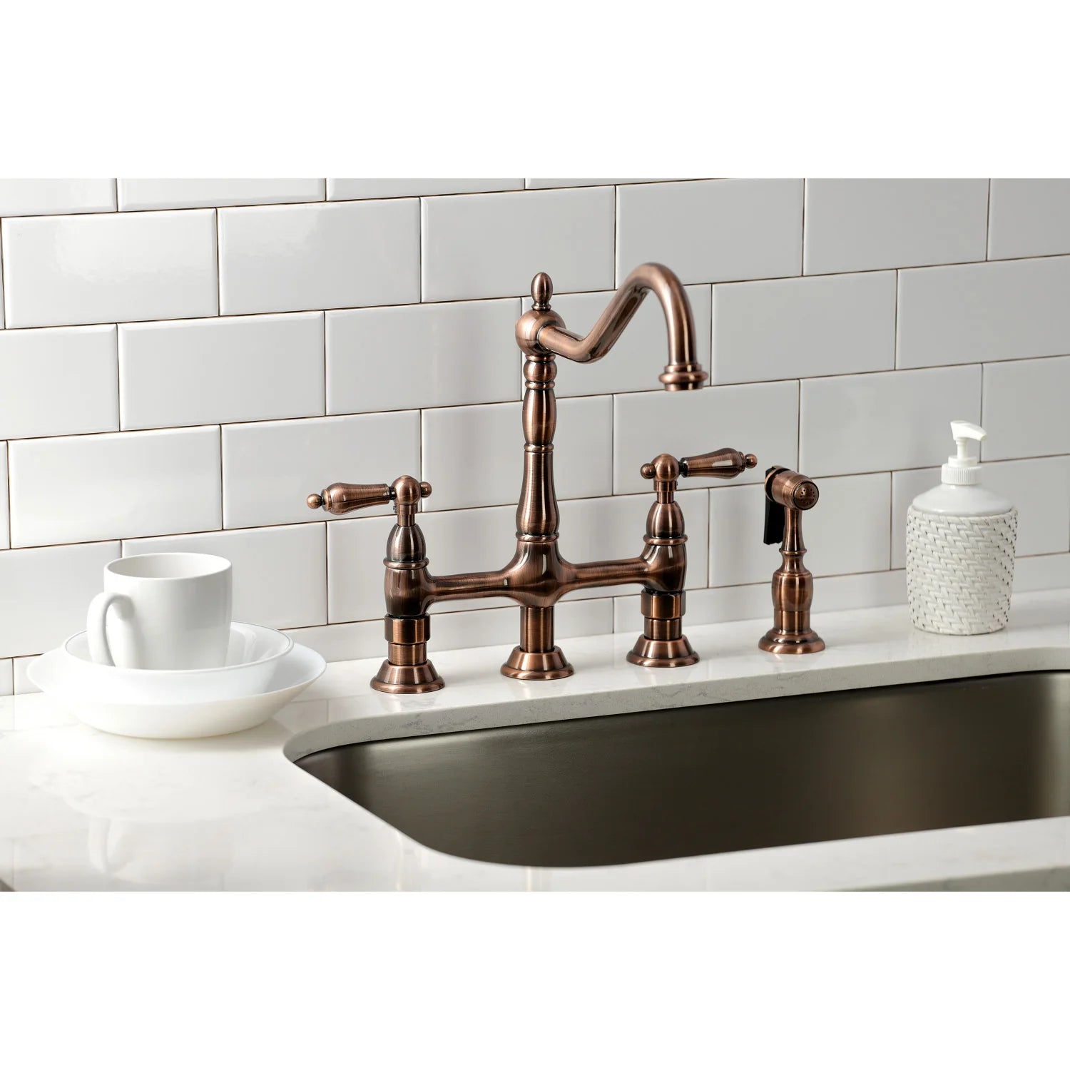 Antique copper bridge kitchen faucet with side sprayer and cross handles on sink
