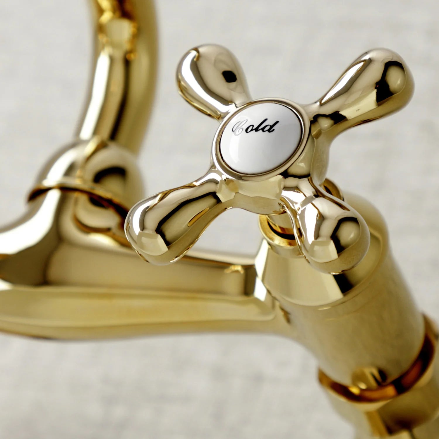 Polished brass faucet handle with round hot/cold dial and cross control stems
