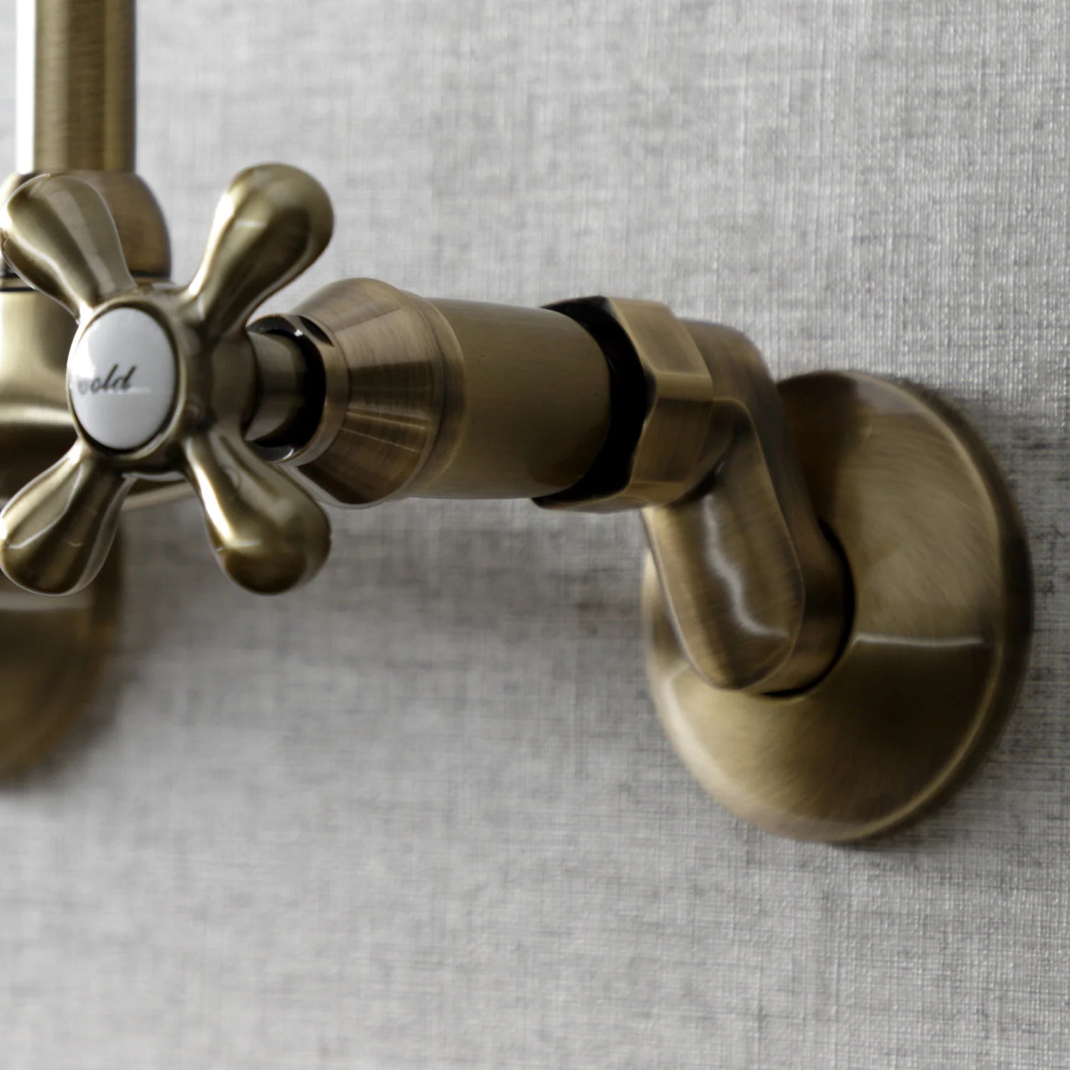 Antique brass faucet handle assembly with round caps and black grip accents