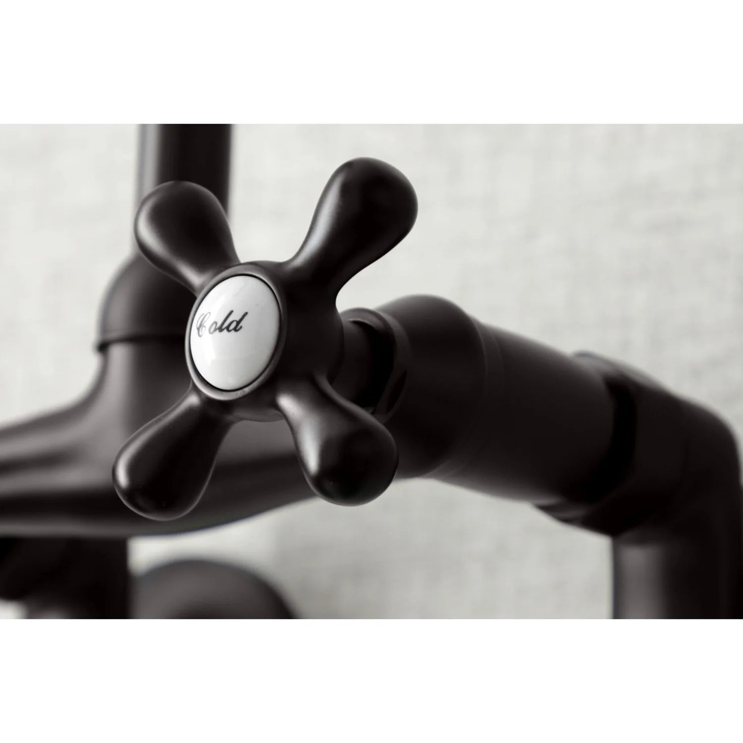 Close-up of oil-rubbed bronze cross handles labeled Hot and Cold