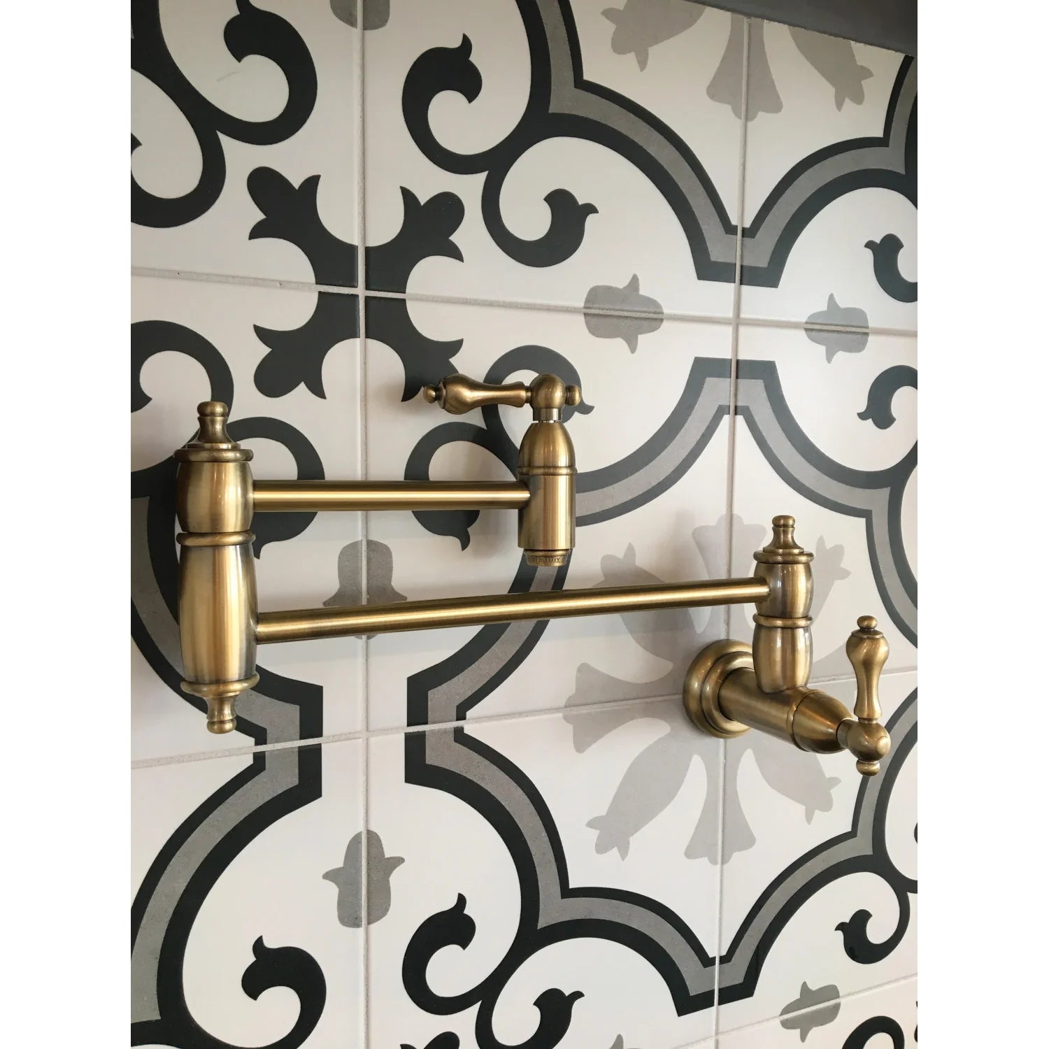 Antique brass wall-mount pot filler faucet on decorative tile backsplash