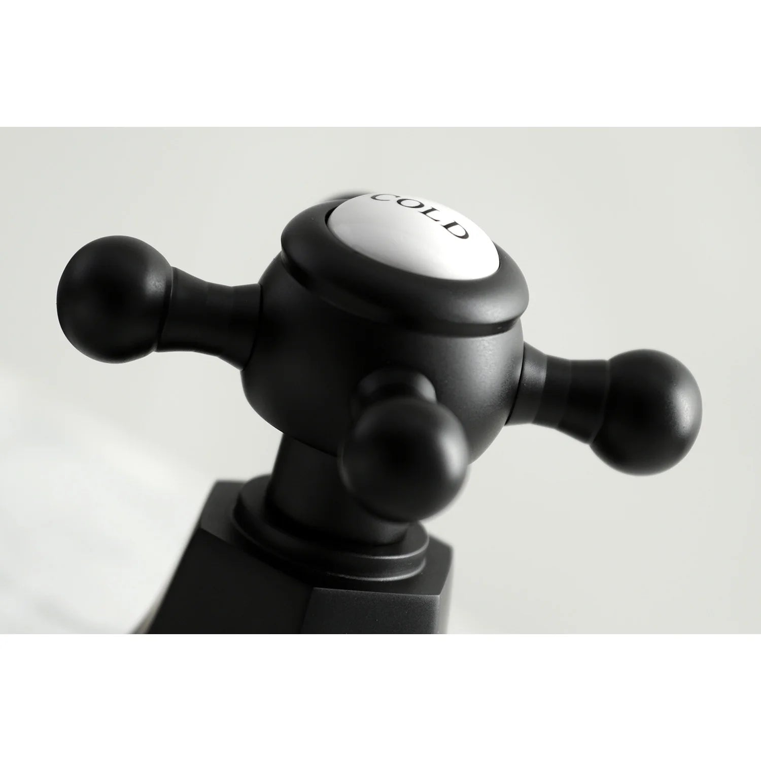 Matte black COLD cross handle with knob detail for widespread faucet