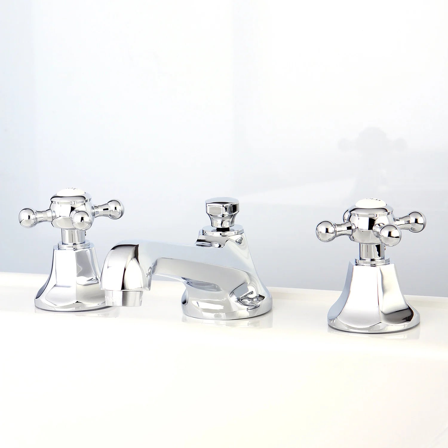 Polished chrome widespread bathroom faucet with two side handles and curved spout