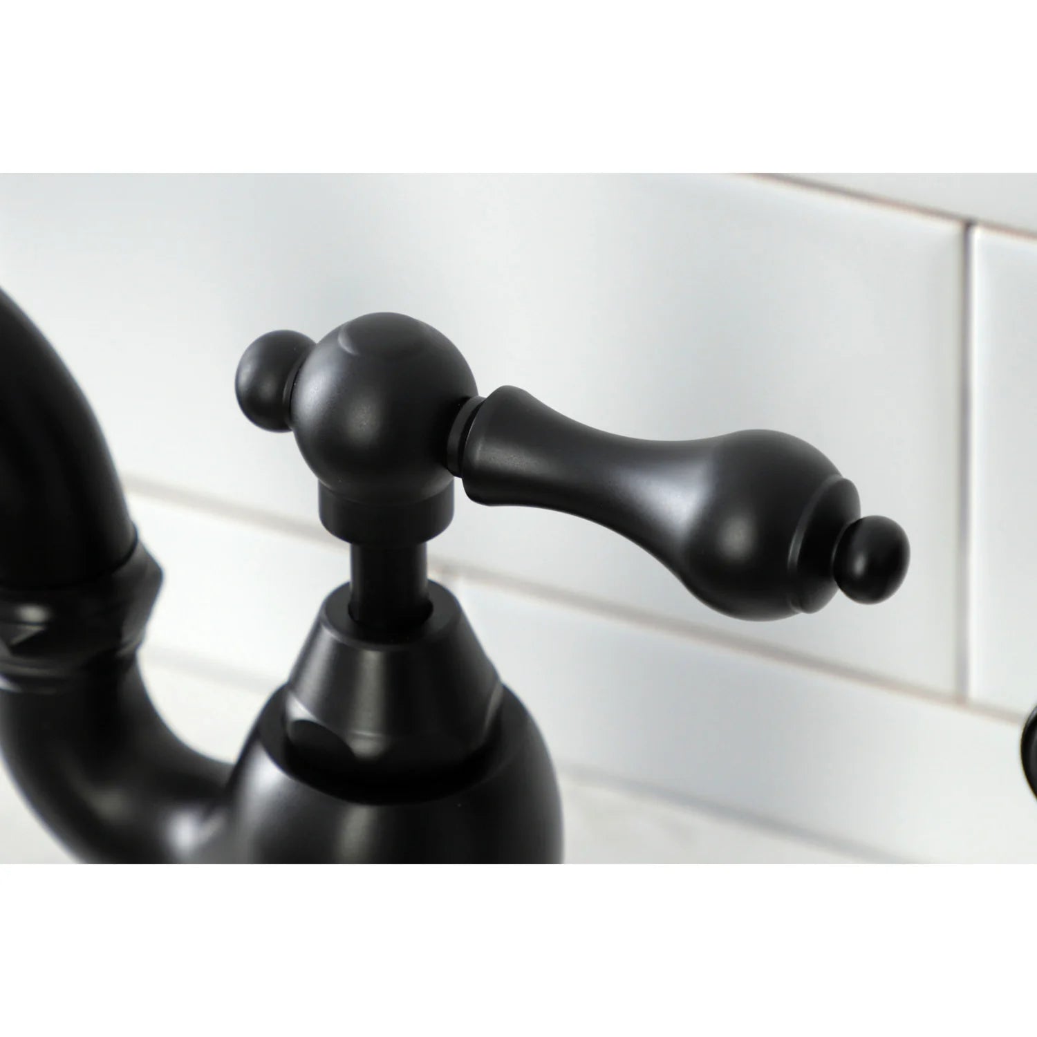 Matte black faucet handle and control knob on bridge kitchen faucet