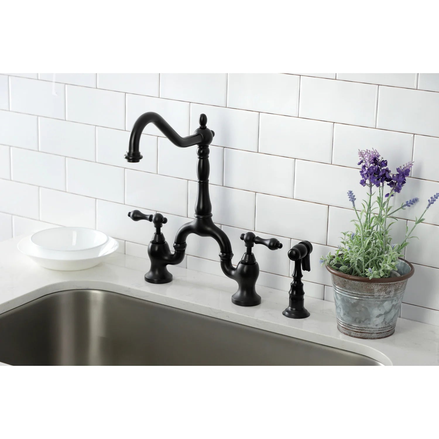 Matte black bridge kitchen faucet set on countertop with side sprayer and handles