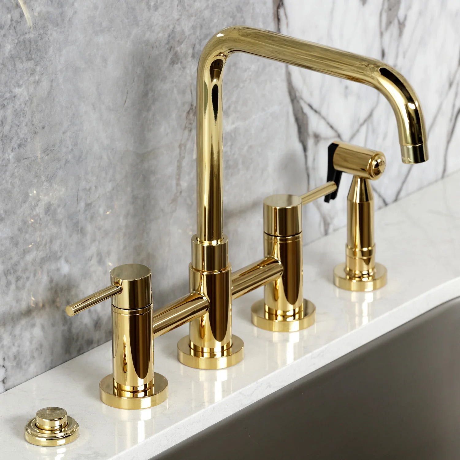 Polished brass bridge kitchen faucet with four handles, gooseneck spout, and side sprayer