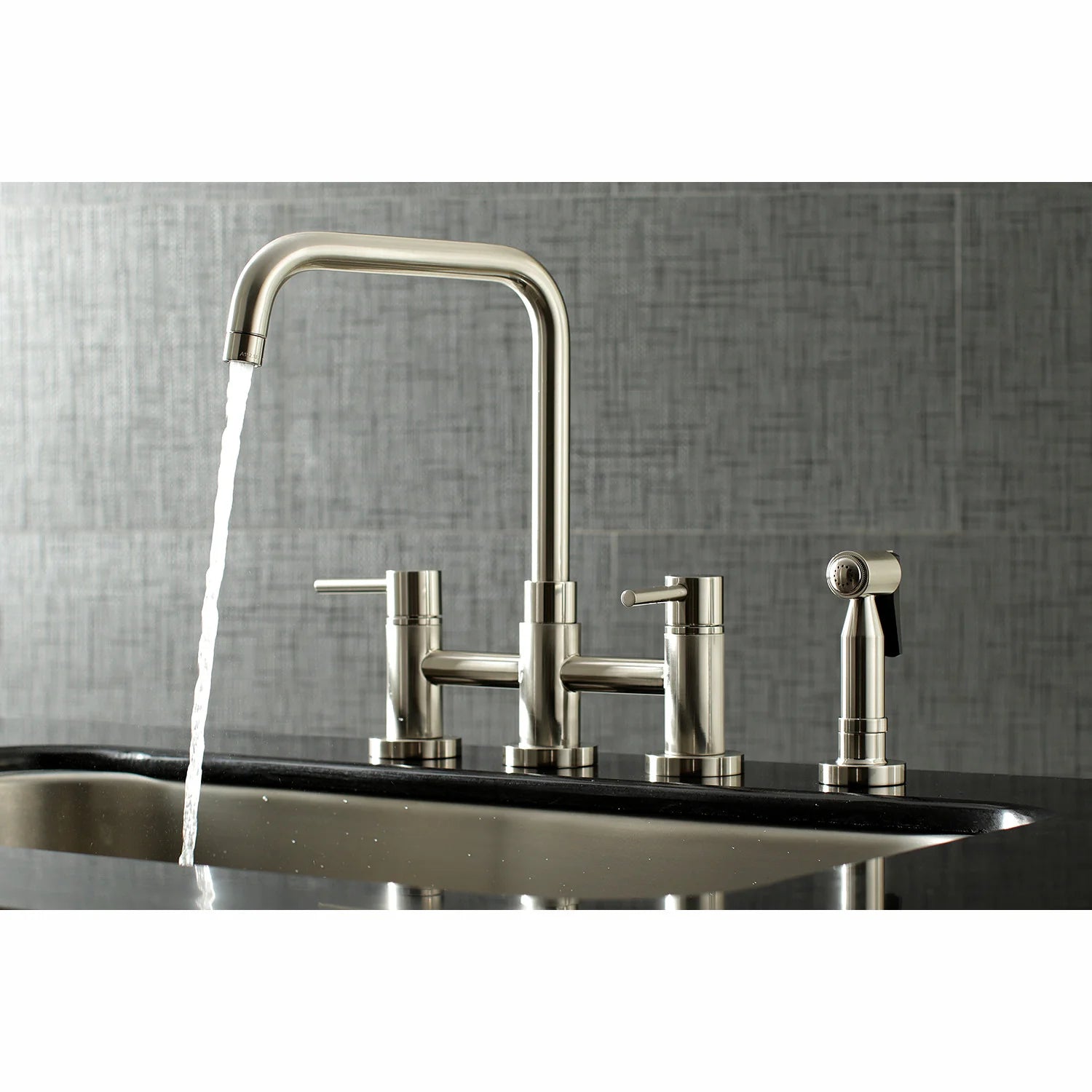 Brushed nickel bridge kitchen faucet over sink with side sprayer