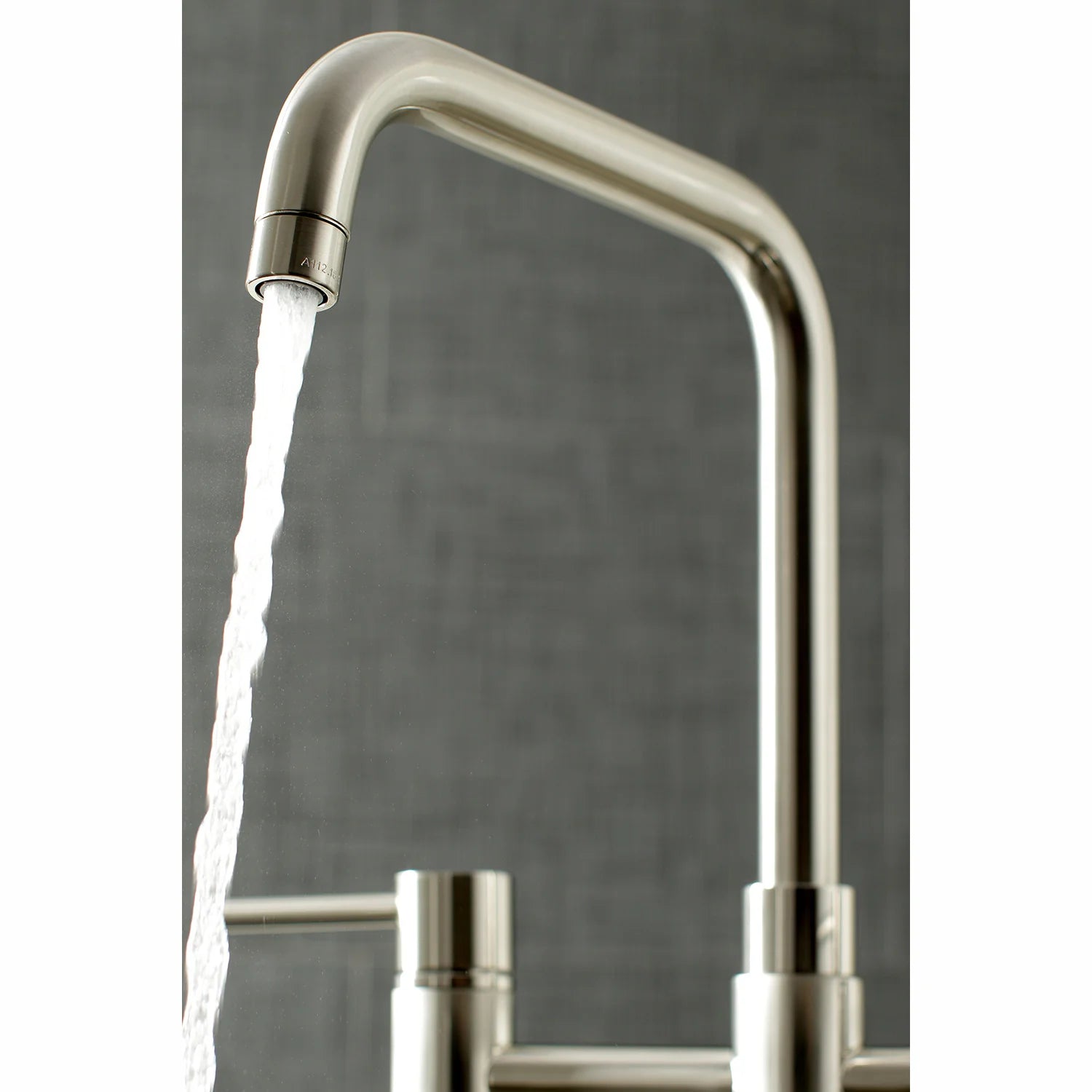 Brushed nickel high-arc faucet spout dispensing water