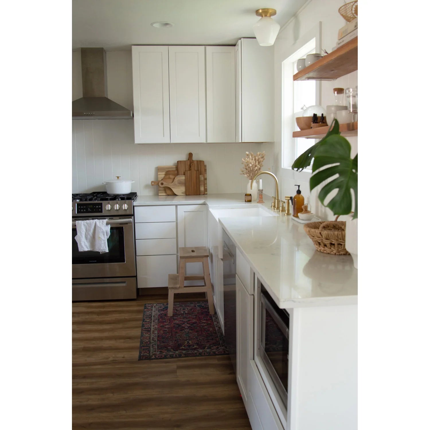 Brushed brass kitchen faucet and widespread handles on white countertop