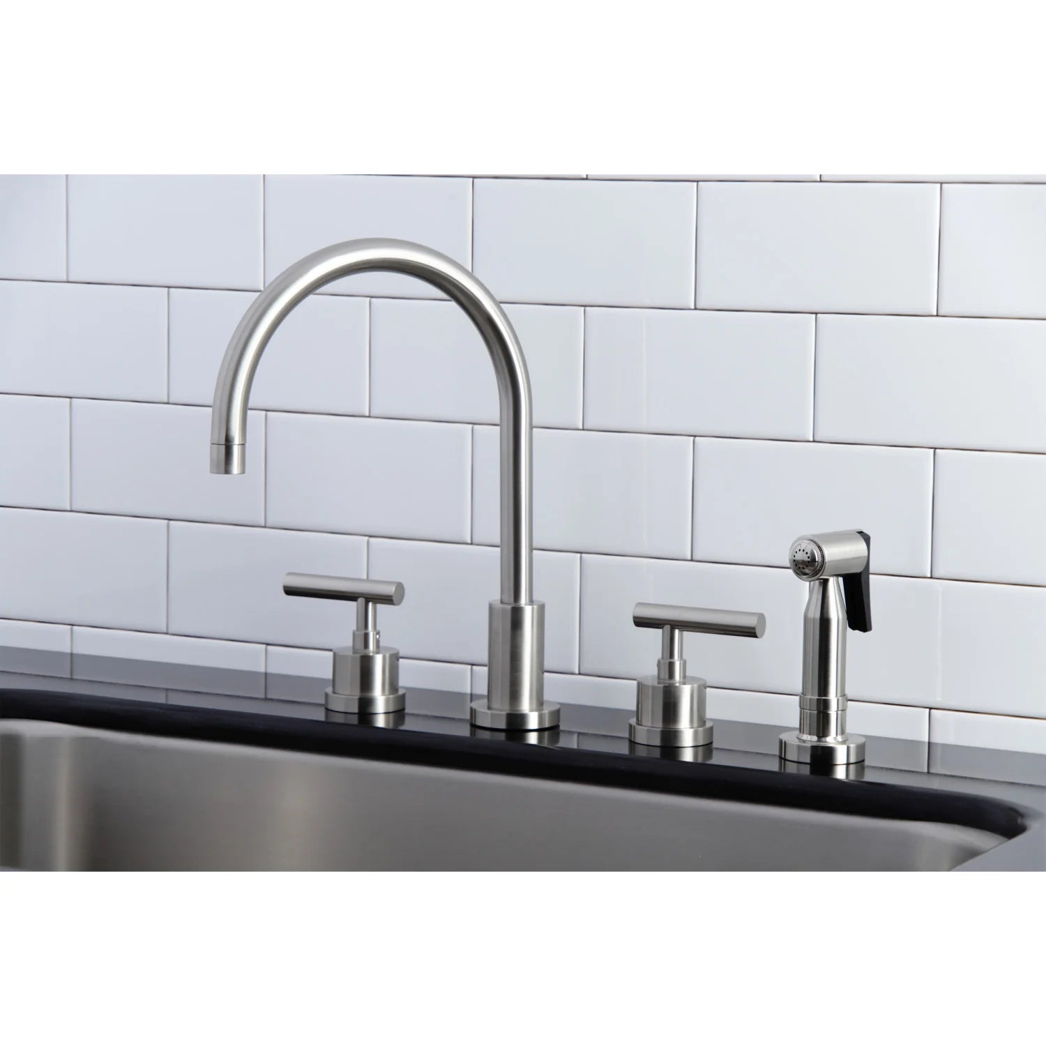Brushed nickel tall gooseneck faucet with two handles and side sprayer on sink deck