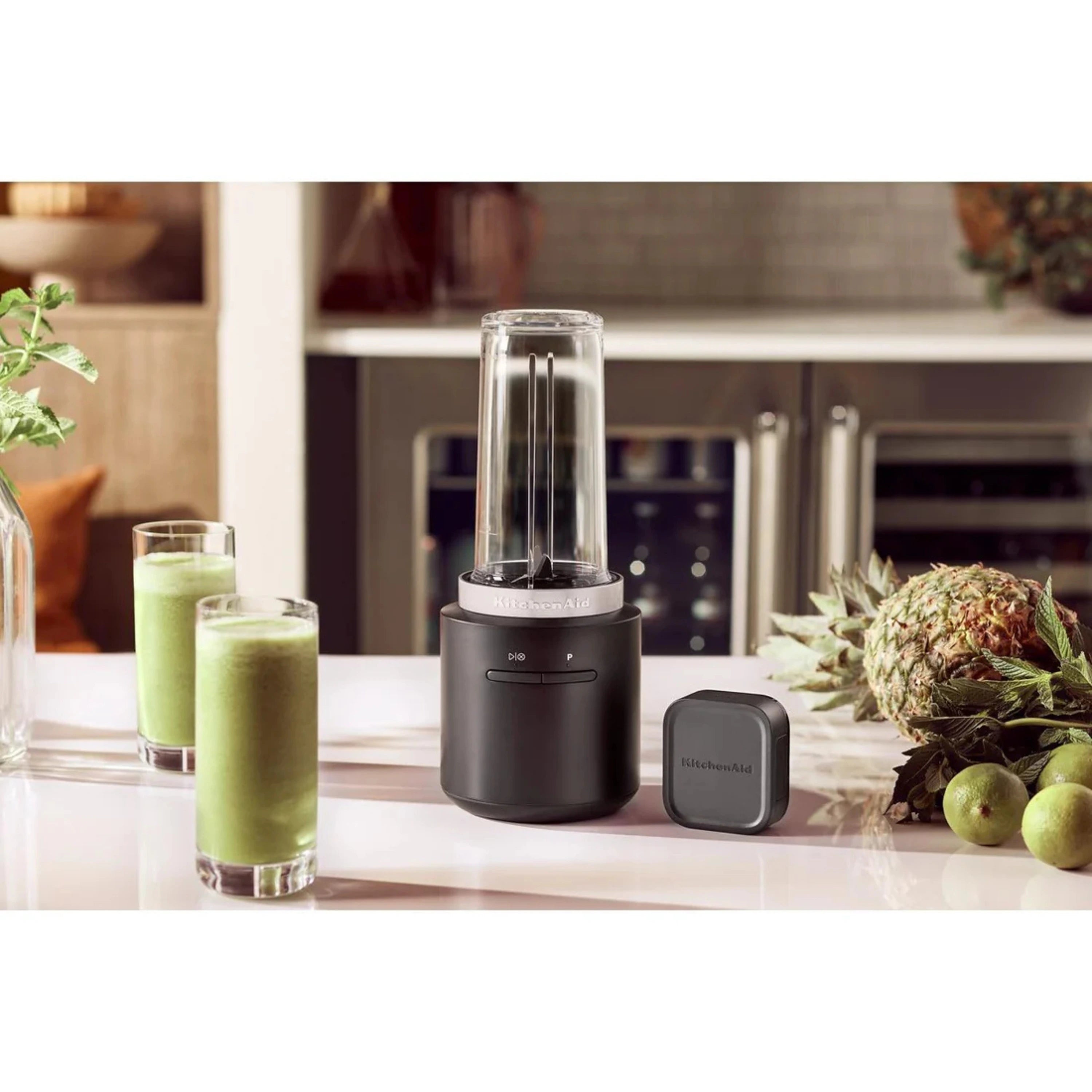 KitchenAid cordless personal blender on countertop with smoothies in tall glasses