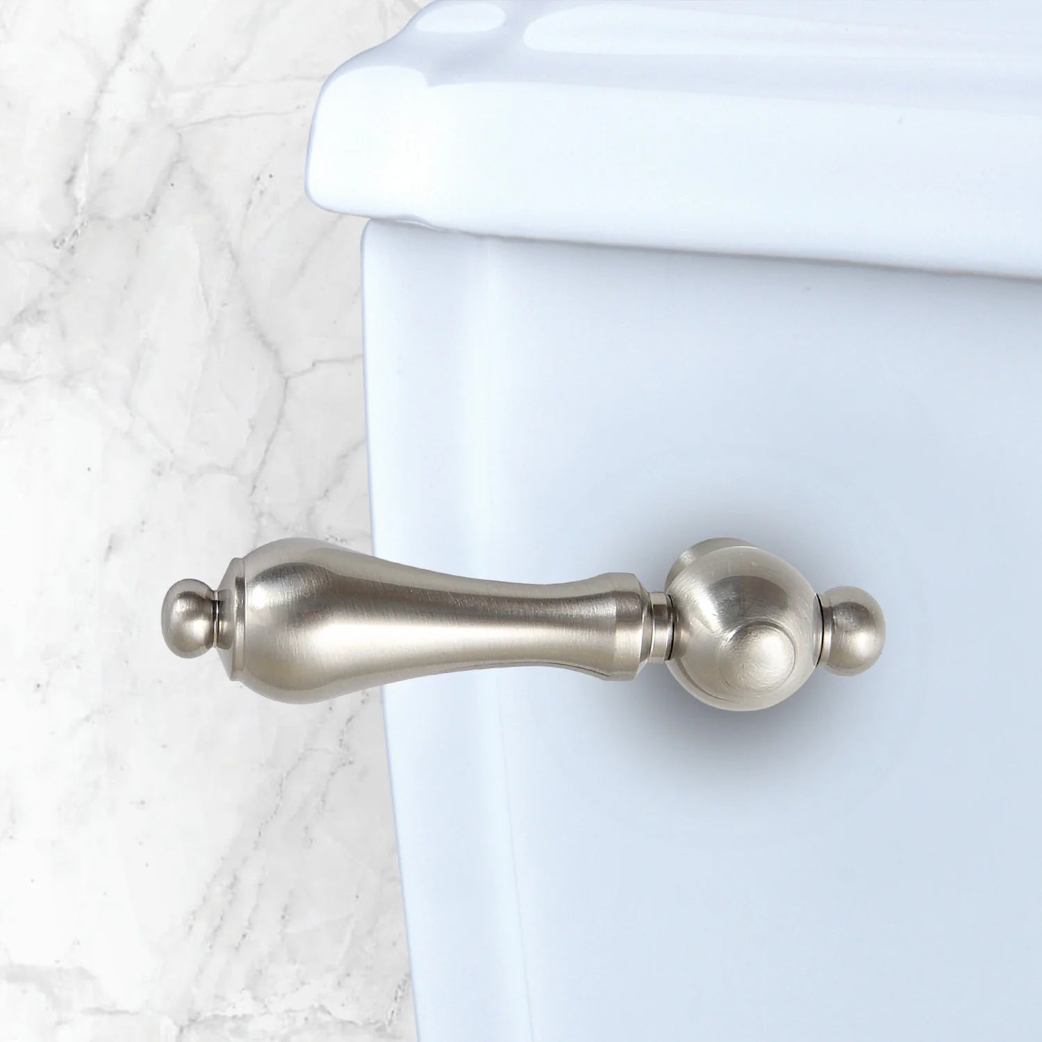 Front-mount toilet tank lever in brushed nickel on tank front, rounded handle
