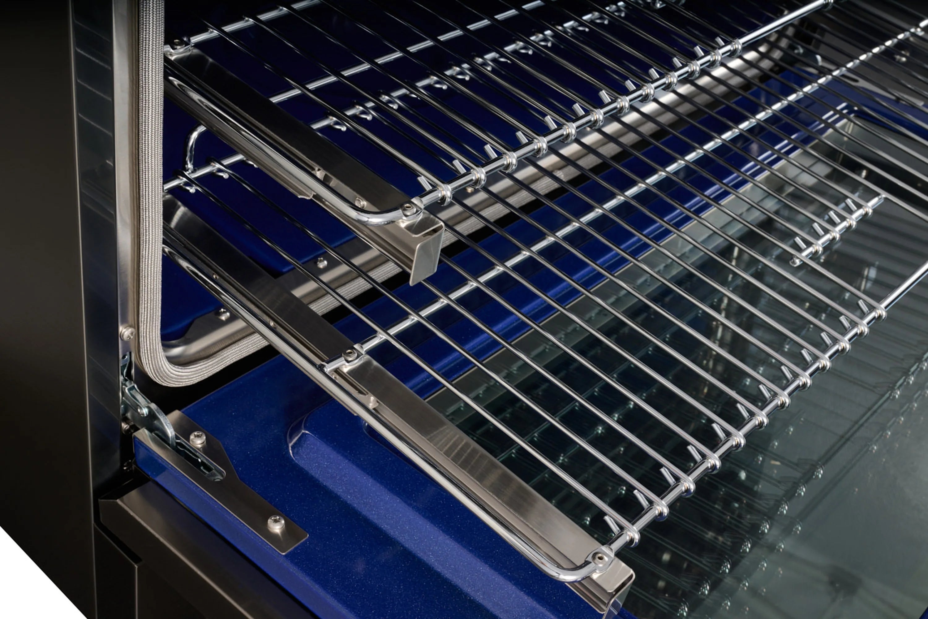 Dual-fuel range oven with wire racks and blue-lit interior behind open door