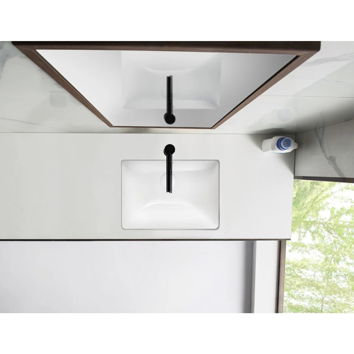Installed white rectangular undermount bathroom sink under countertop