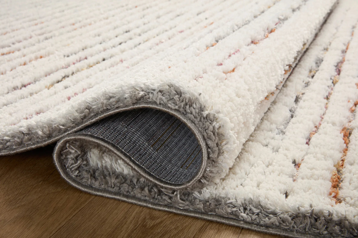 Corner detail of ivory shag runner rug with gray bound edge and visible backing