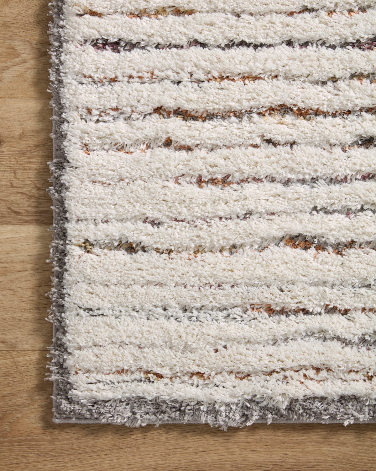 Ivory shag rug with gray edge binding, striped rows of soft high pile