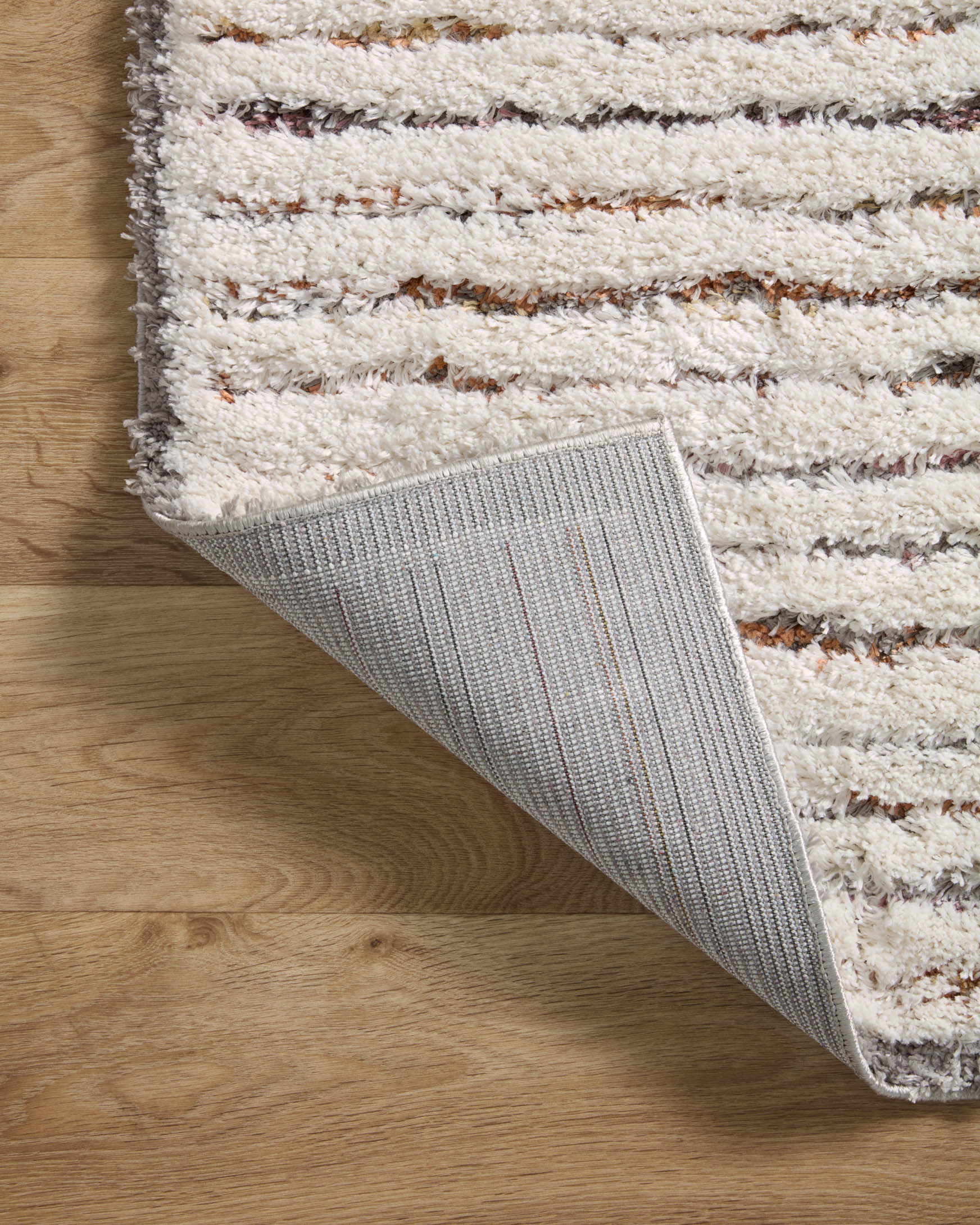 Ivory shag runner rug rolled edge showing gray woven backing