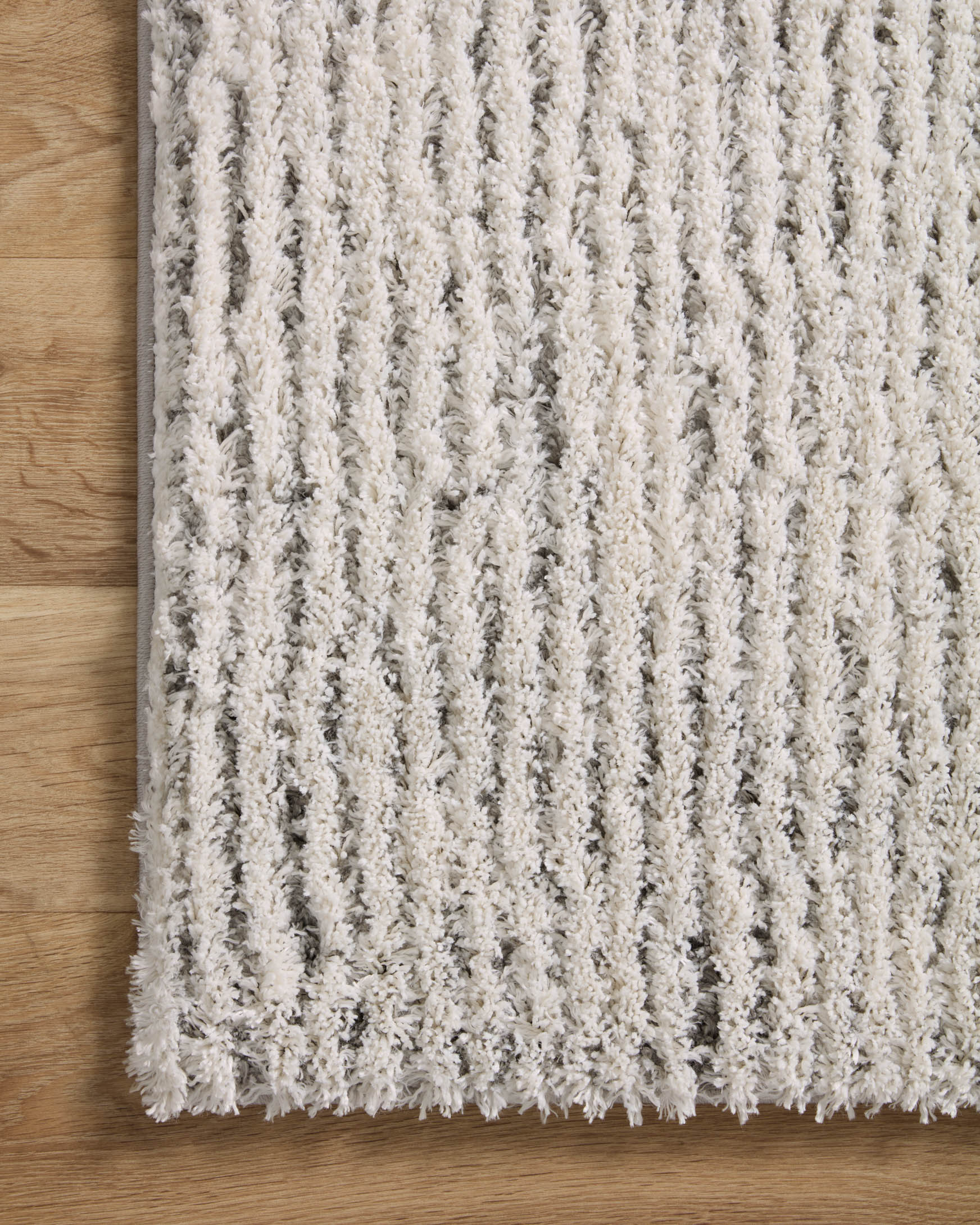 Ivory shag rug with vertically ribbed texture and subtle grey accents