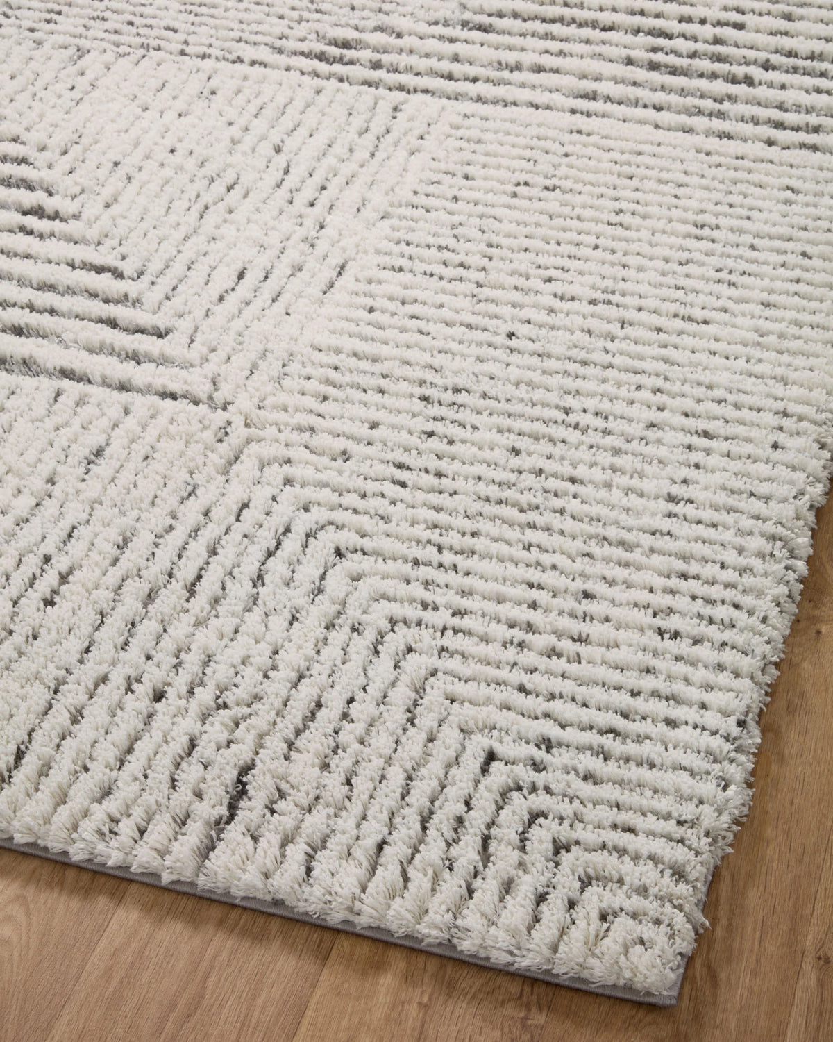 Close-up of ivory and grey shag rug with textured geometric line pattern