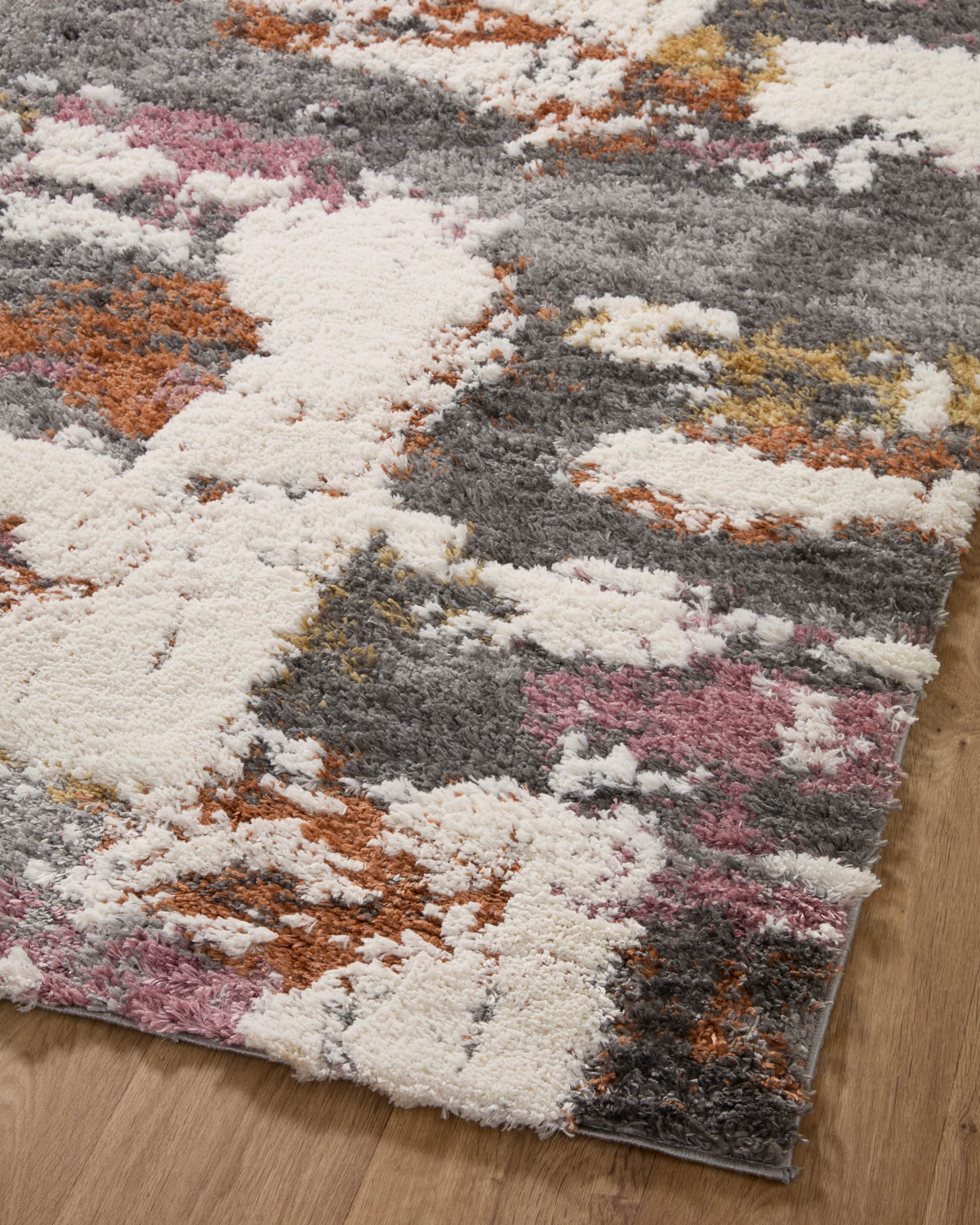 Grey shag runner rug top view with cream, orange, and pink abstract distressed blocks