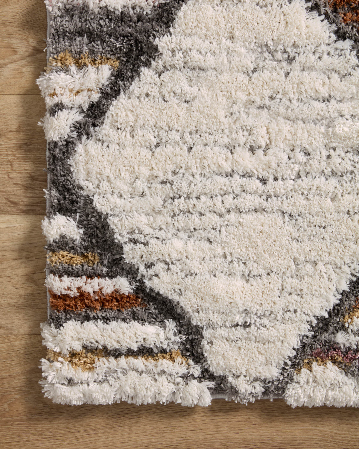 Ivory shag rug panel with charcoal, gray, and orange horizontal striped blocks.