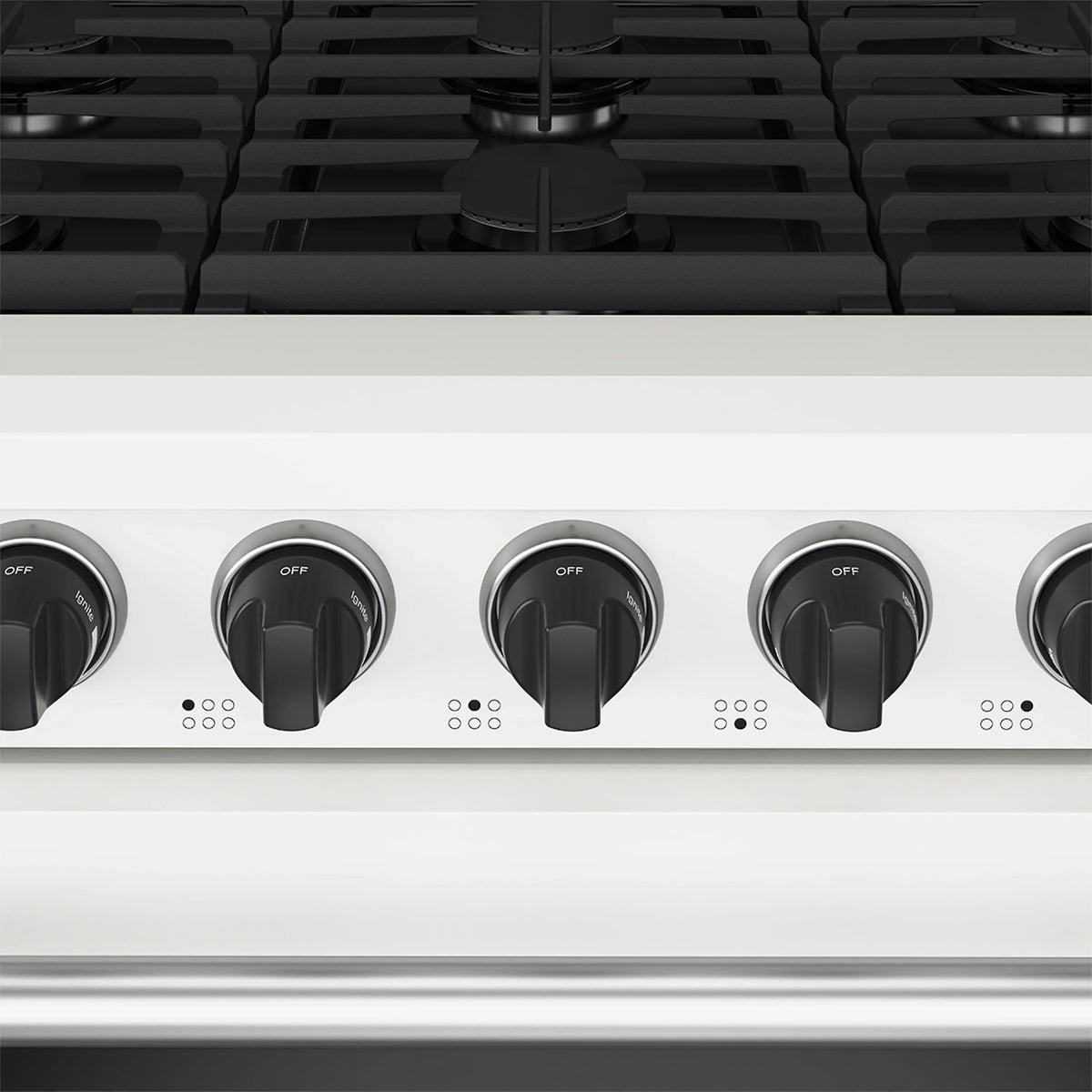Close-up of white range control knobs across the cooktop panel