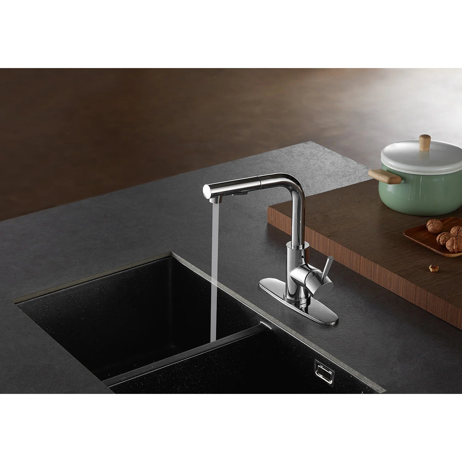 Polished chrome pull-out kitchen faucet with sprayer spraying water over sink