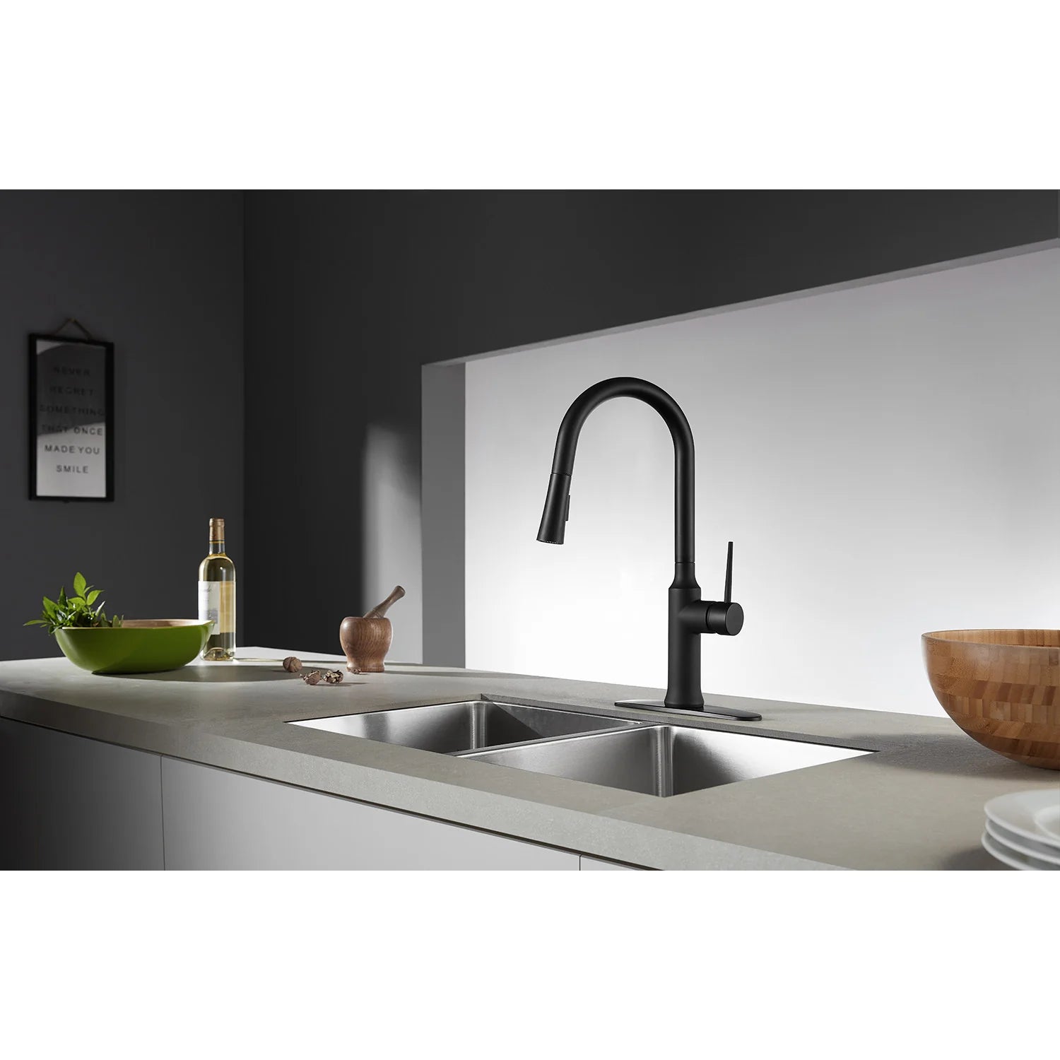 Matte black single-handle pull-down kitchen faucet above sink with arched spout