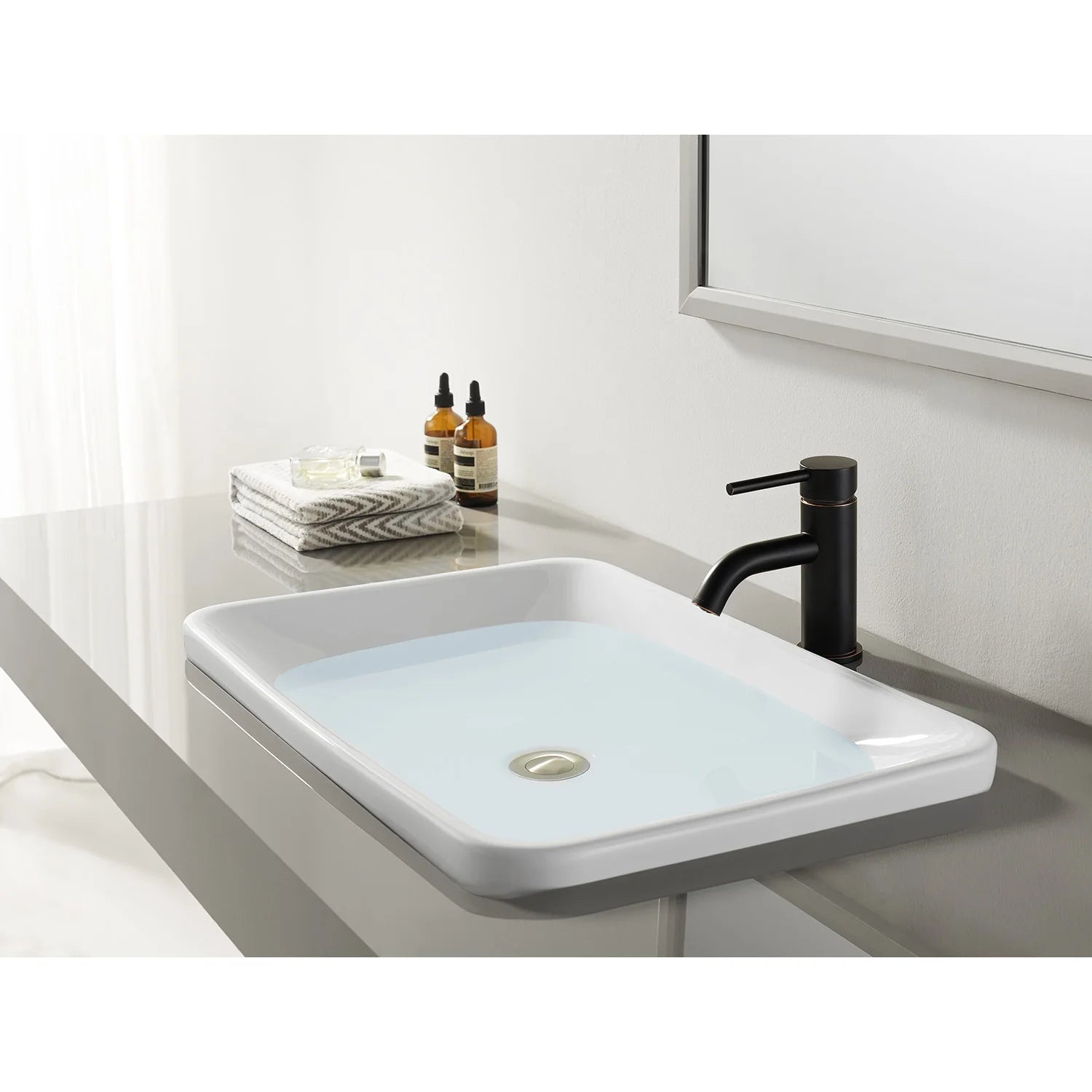 Dark bronze one-handle bathroom faucet on a rectangular white sink