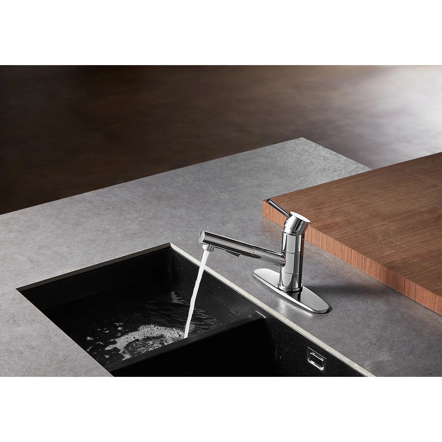 Polished chrome kitchen faucet over a black sink with pull-out sprayer