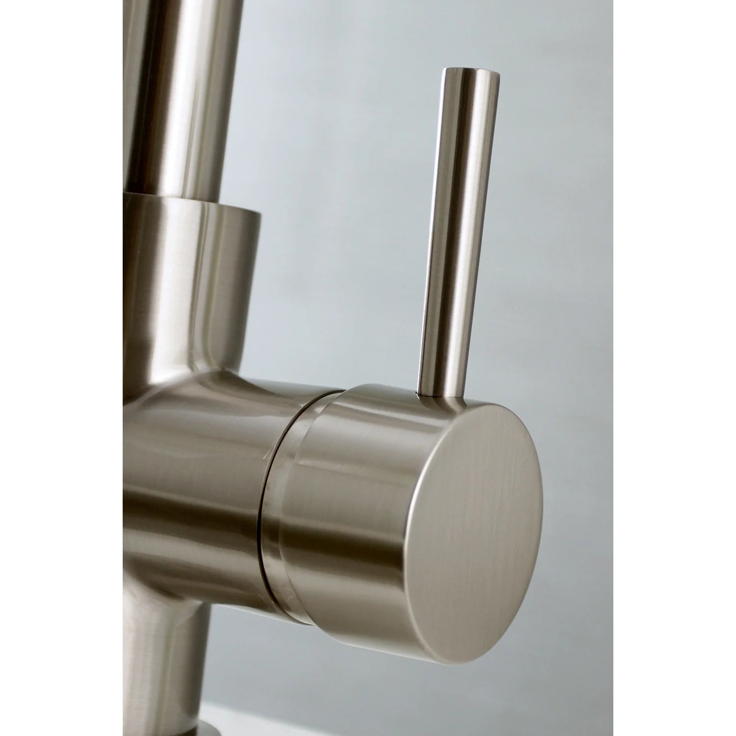 Brushed nickel single-handle faucet with control lever and spout base
