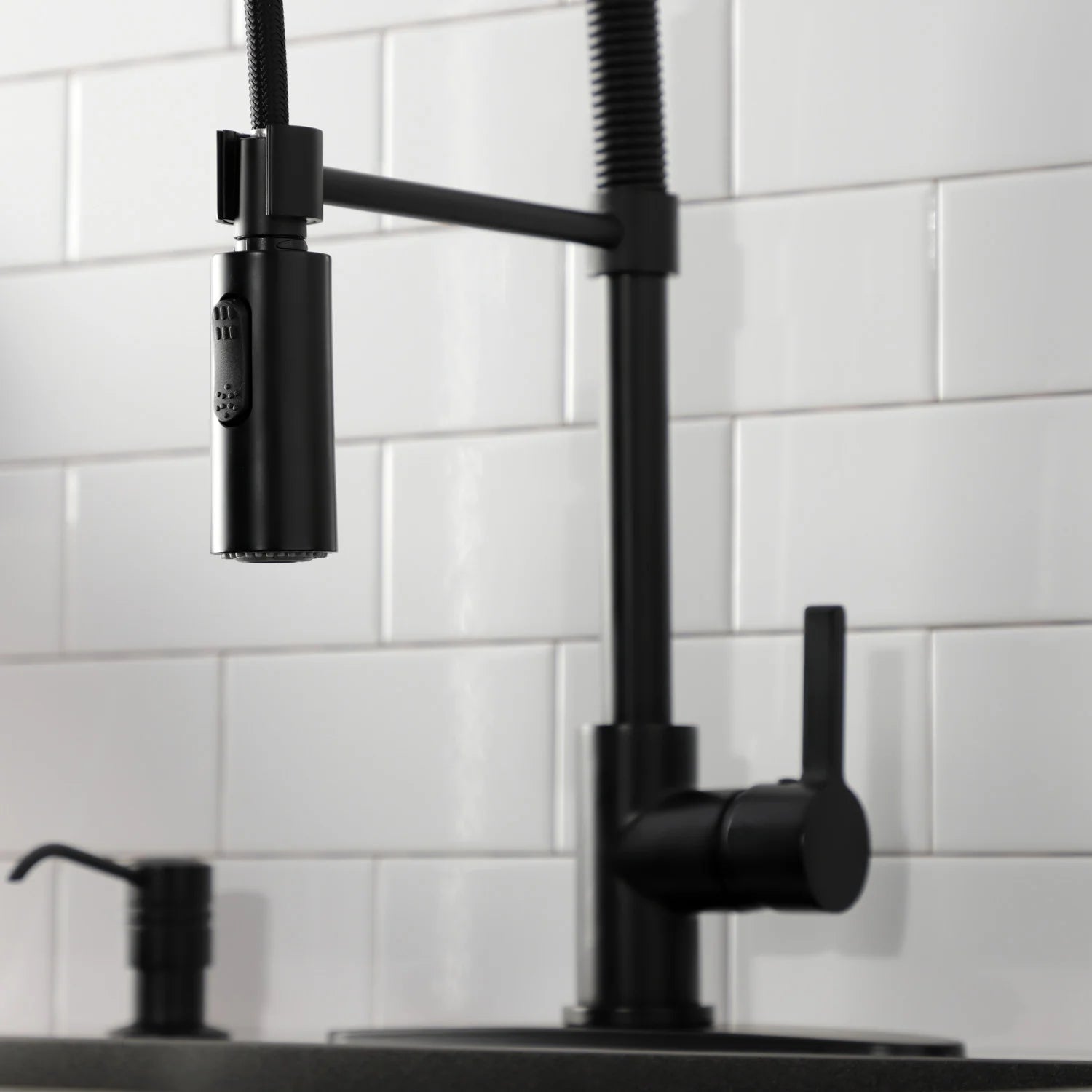 Matte black single-handle deck faucet with cylindrical spout and spray head