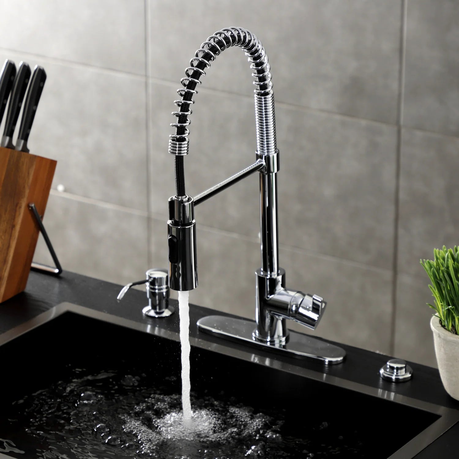 Polished chrome pre-rinse faucet with arched hose and water stream at outlet