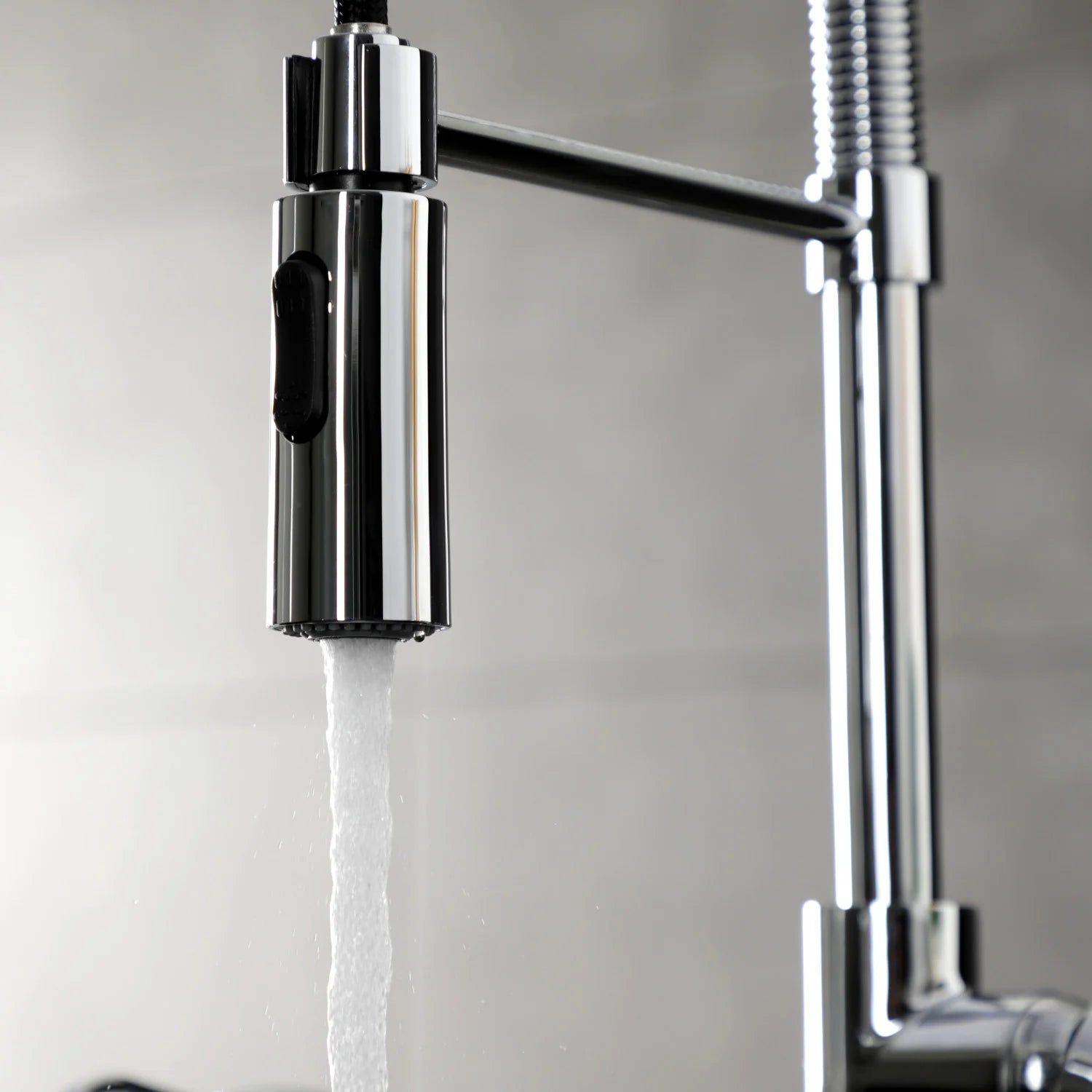 Polished chrome pre-rinse faucet spout releasing a steady water stream