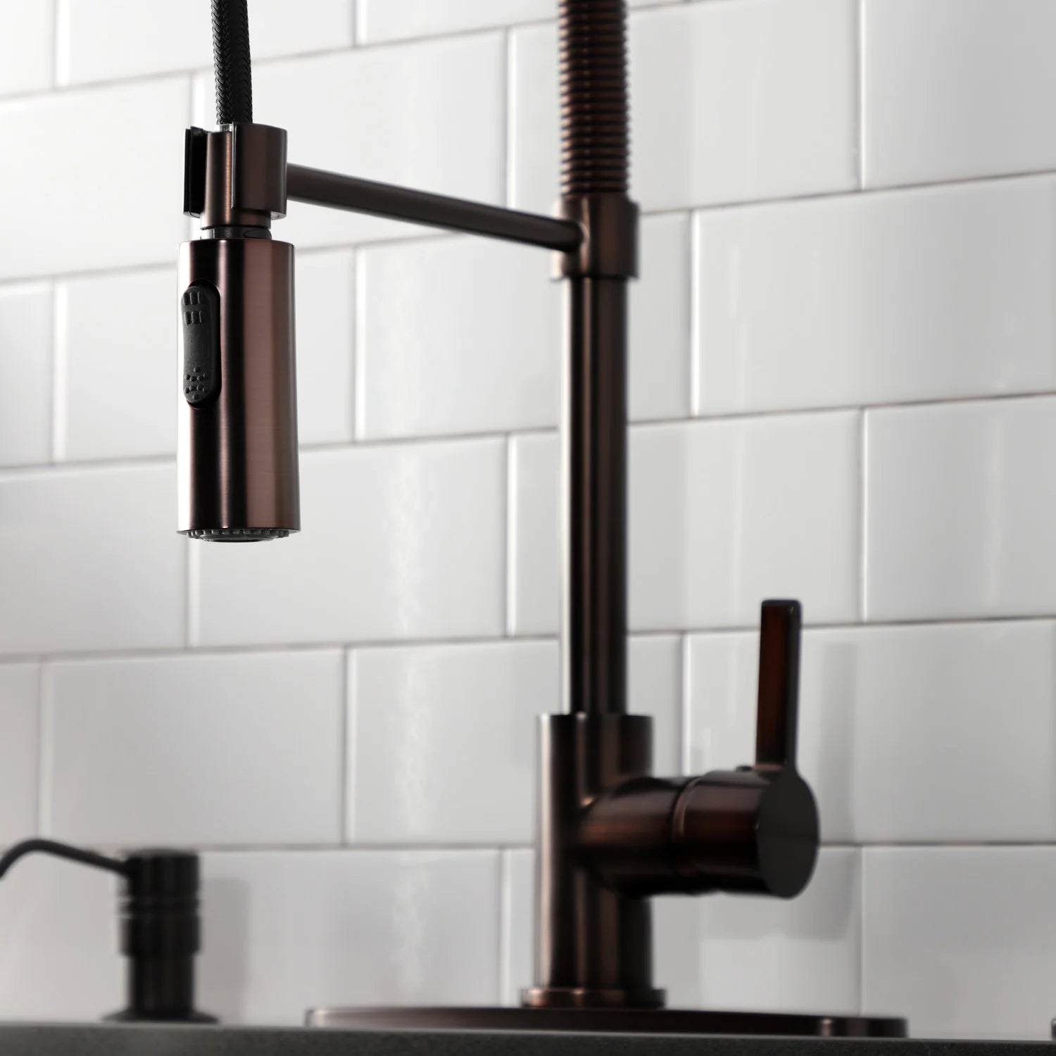 Oil-rubbed bronze kitchen faucet close-up with single handle and side sprayer