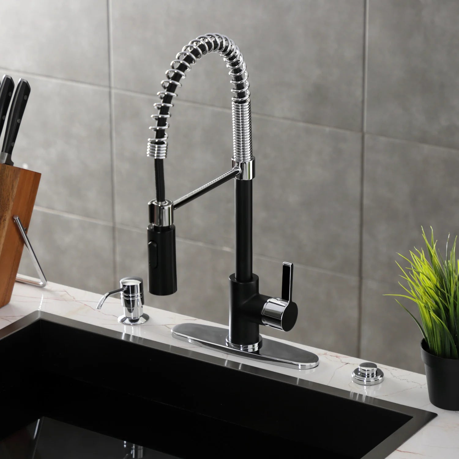 Matte black deck-mount faucet with flexible chrome hose, chrome spray head, and lever handle
