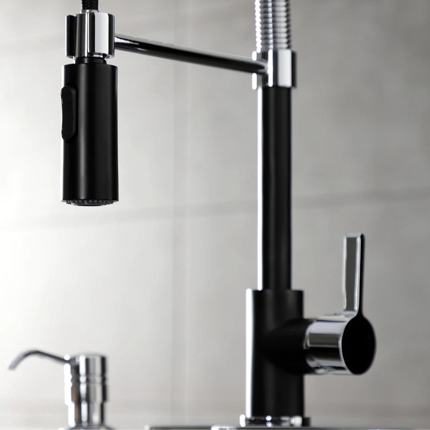 Matte black kitchen faucet with single handle and flexible spray hose in front view