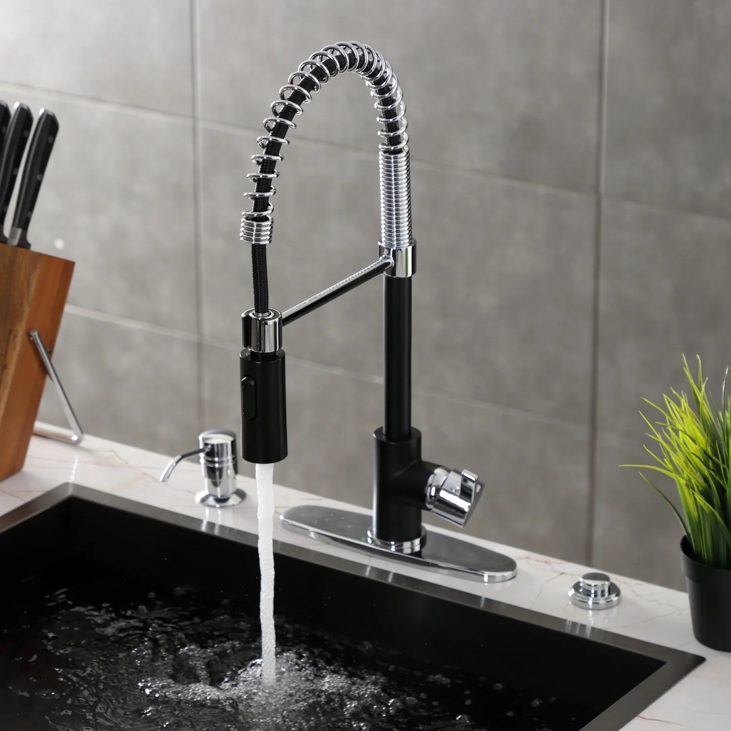 Matte black deck-mount faucet with chrome spray head, arched hose, and water flow