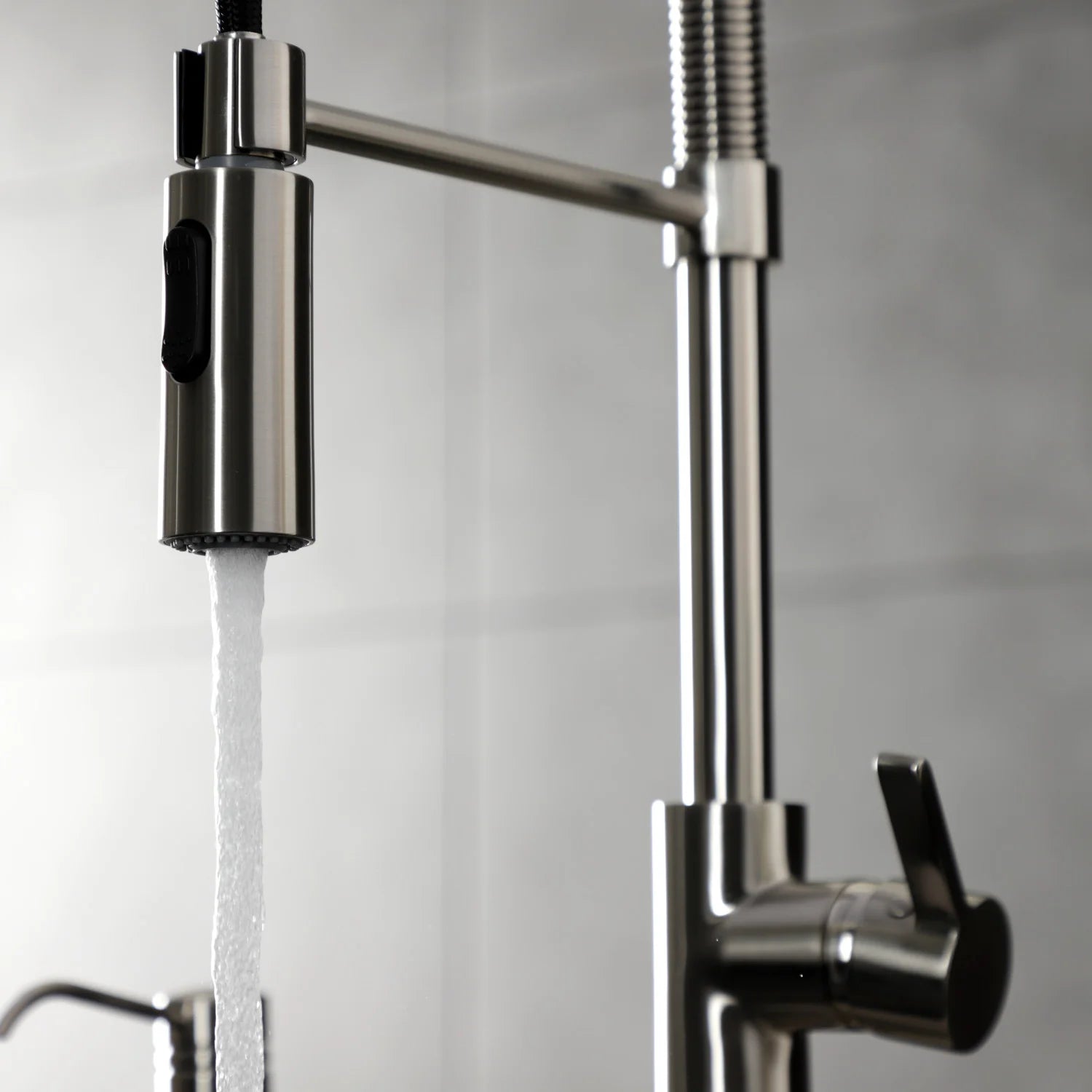 Brushed nickel pre-rinse faucet with single handle and water stream from spray head