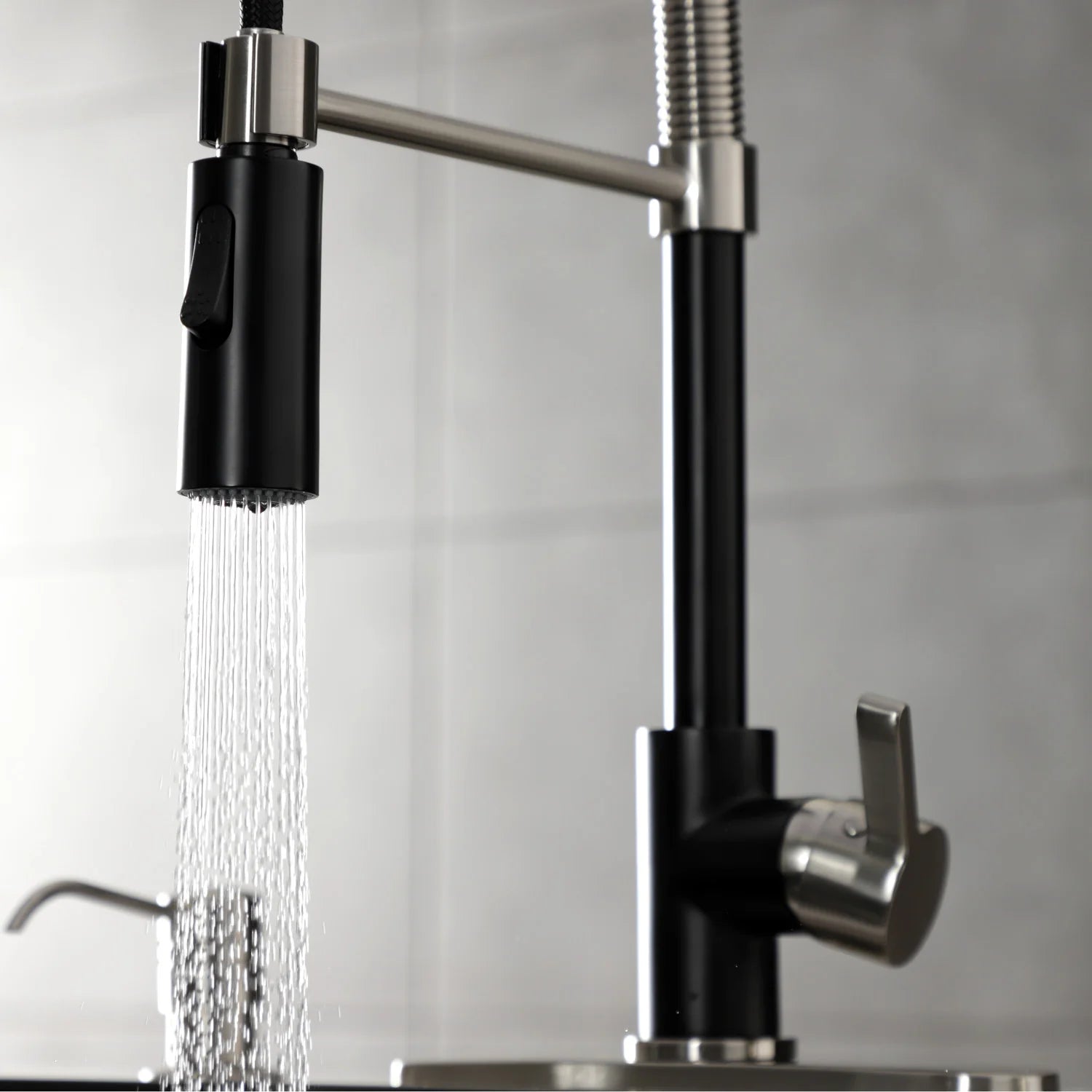 Deck-mount kitchen pre-rinse faucet with matte black handle, brushed nickel spout, water stream