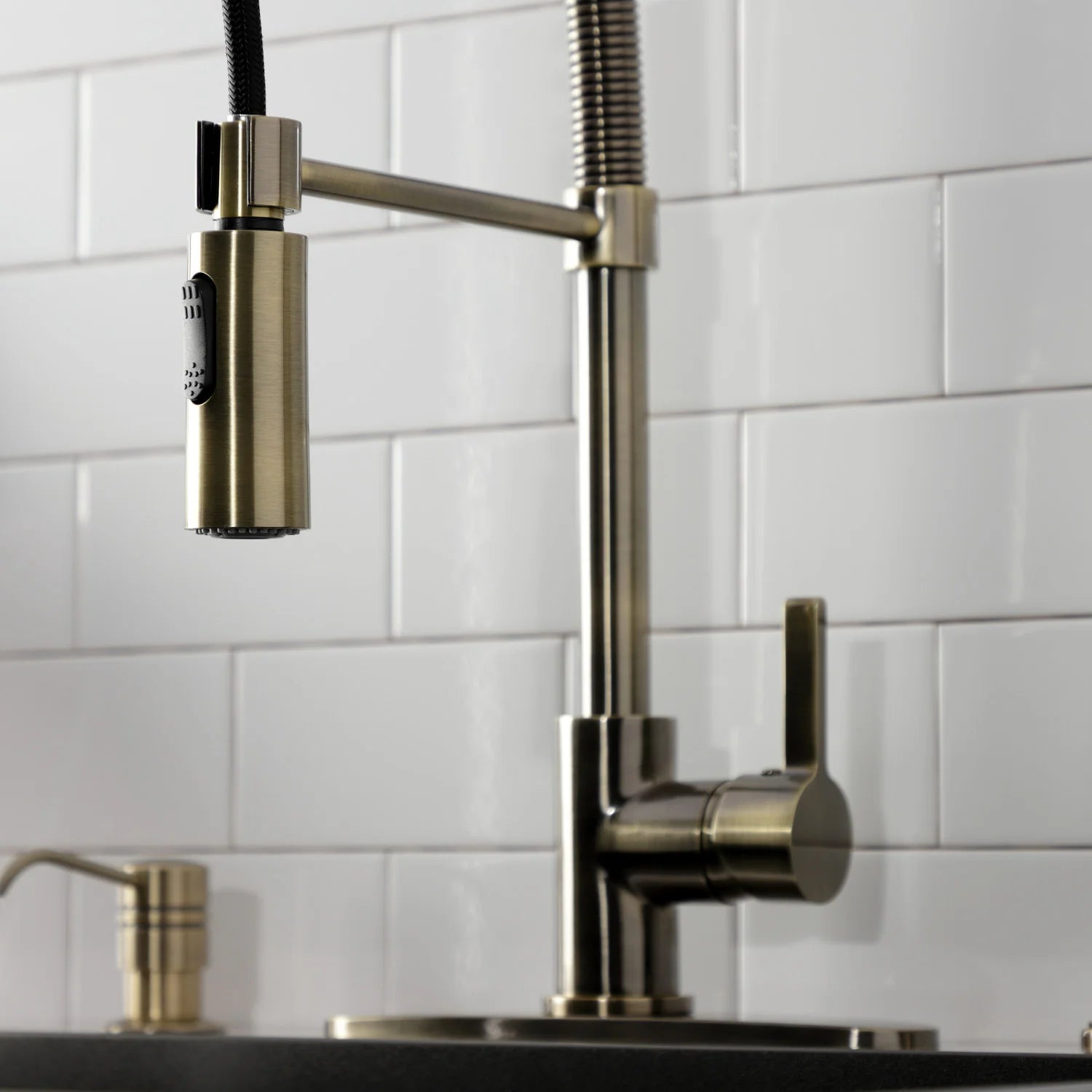 Antique brass kitchen faucet with single lever, side sprayer outlet, and tall riser
