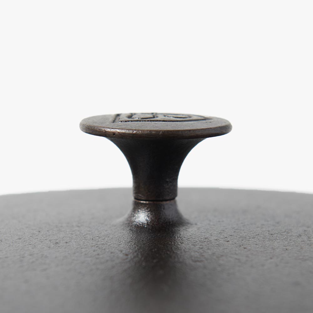 Cast iron lid knob on matte dark surface for skillet cover