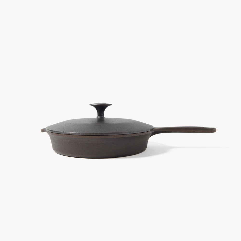 Cast iron skillet lid on skillet with center knob and long side handle