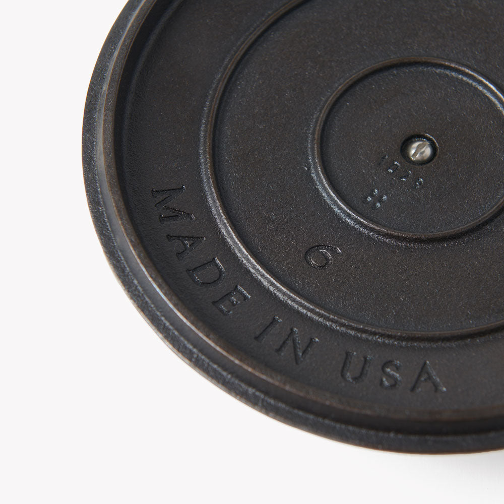 Close-up of cast iron skillet lid underside with “FIELD COMPANY” stamp