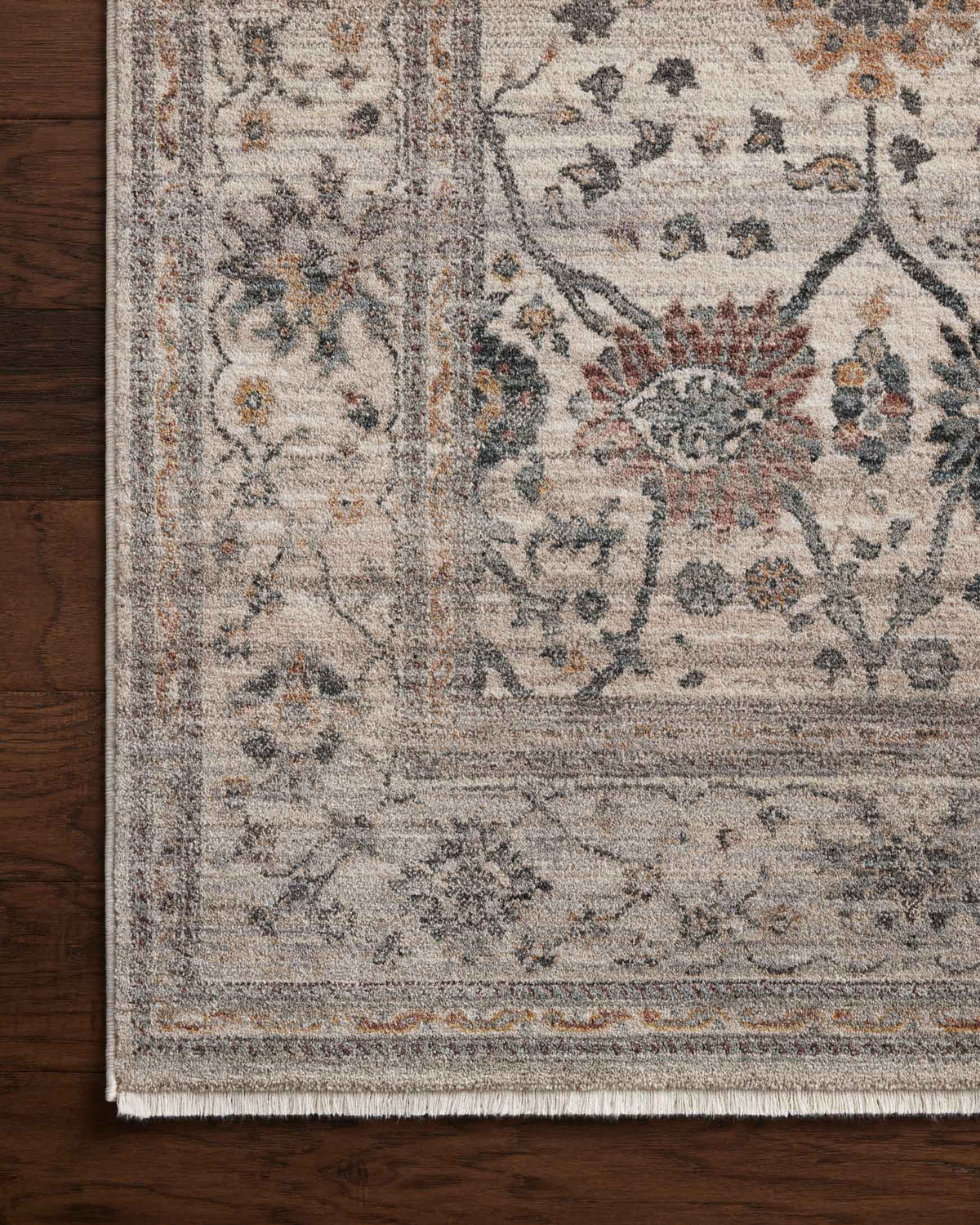 Round rug close-up: blue-gray and tan distressed motifs with flat border, fringed edge
