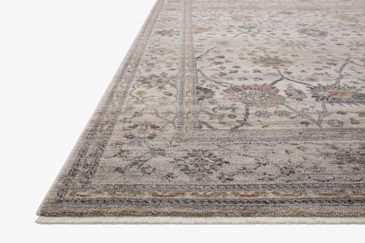 Gray and beige area rug with distressed medallion pattern and fringe edge